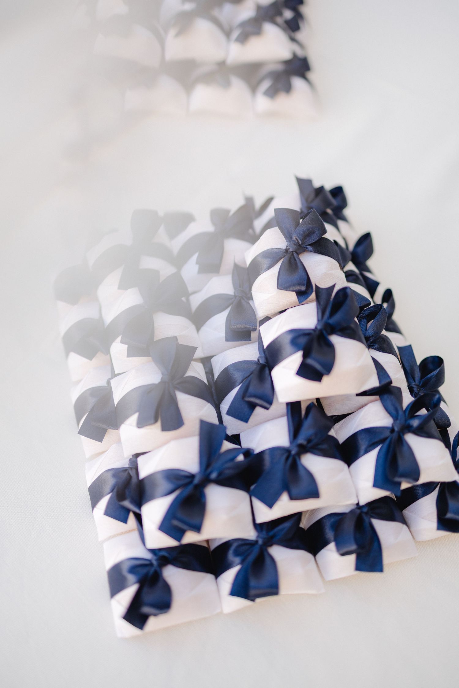 Collection of navy blue and white decorative bows arranged in neat rows.