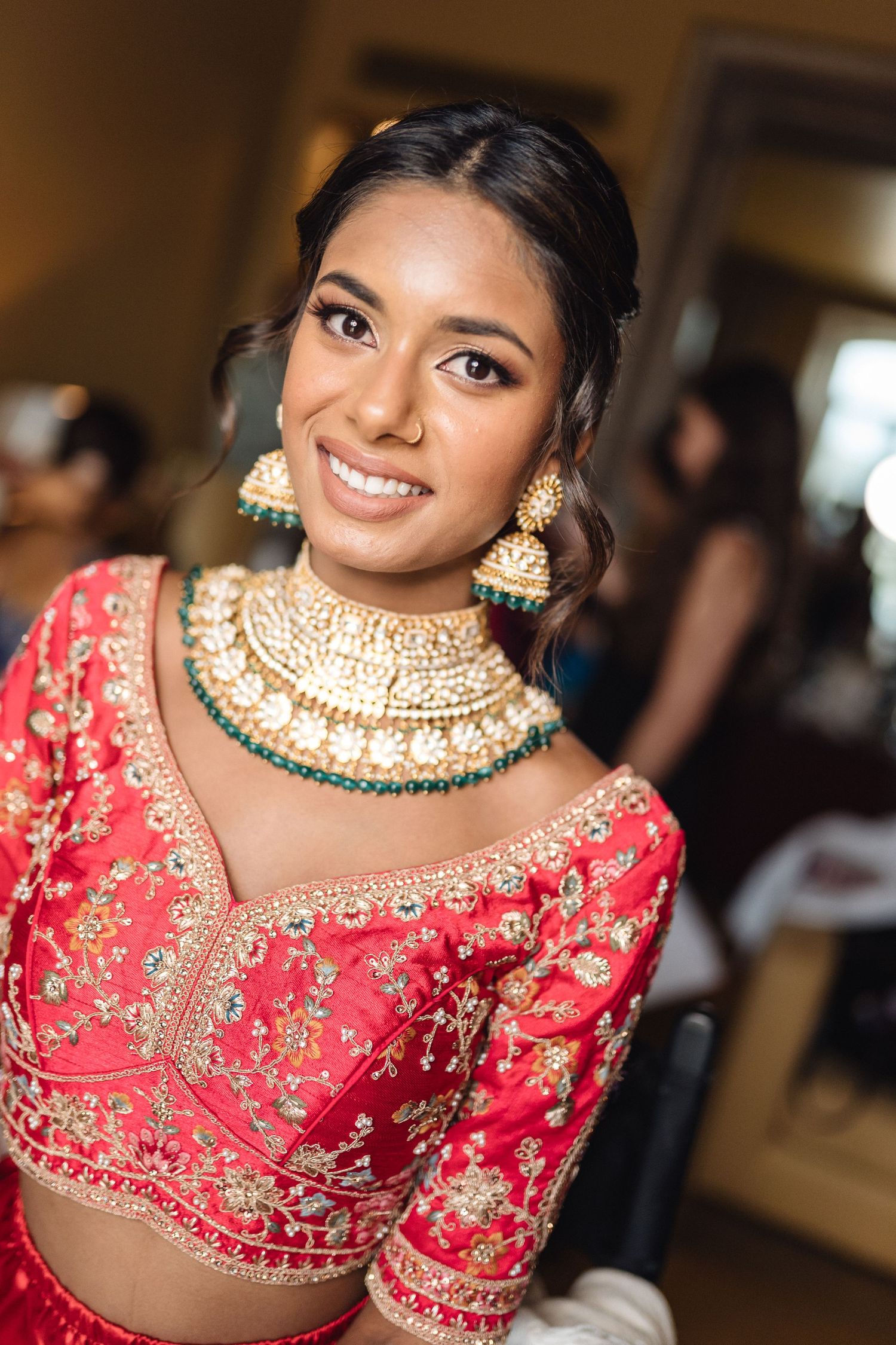 Stunning bridal jewelry featuring an ornate gold choker necklace with emerald accents and traditional Indian design.