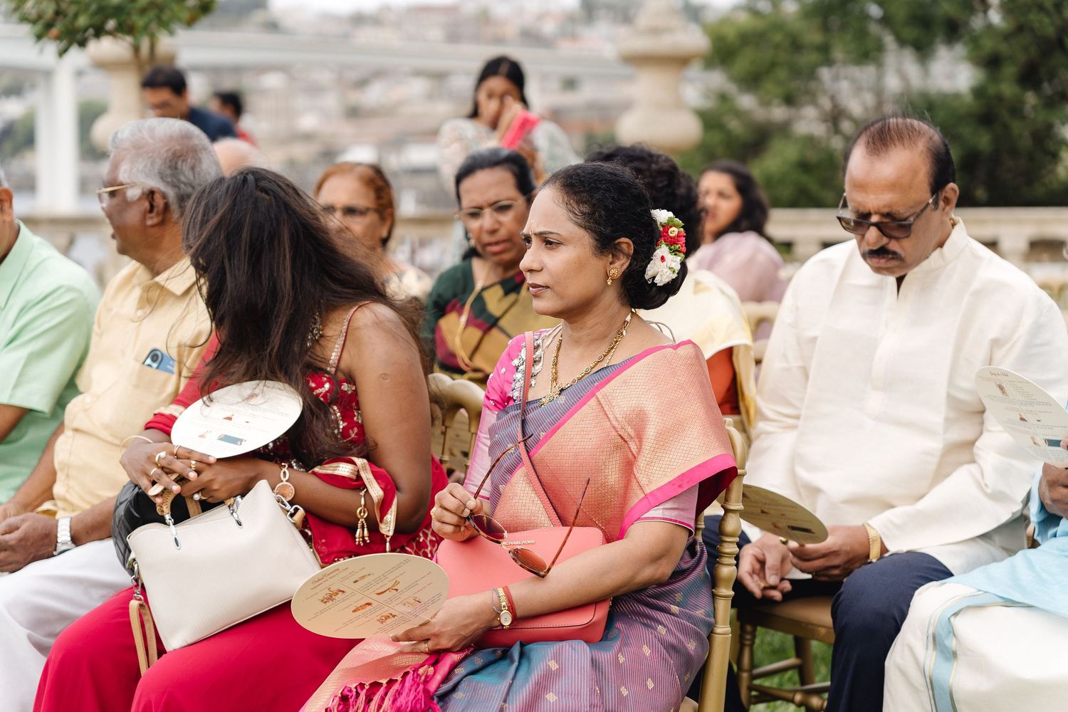 Wedding guests seated outdoors enjoying the celebration festivities.