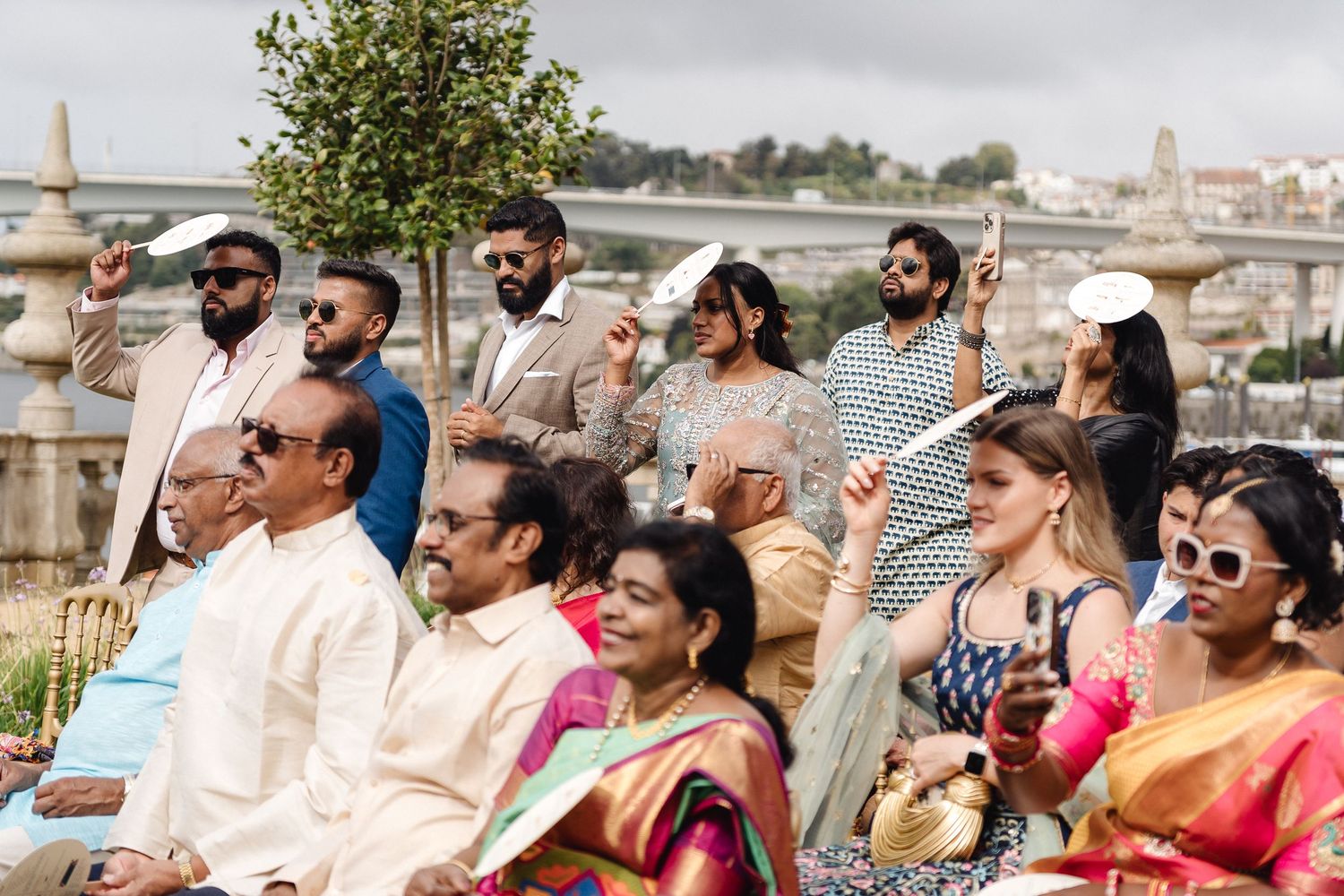 Wedding guests seated outdoors enjoying a celebration under natural lighting.