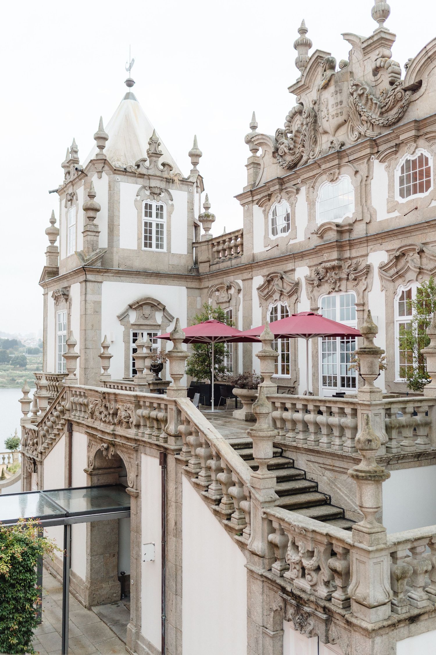 Ornate baroque staircase with white stone balustrades and decorative architectural details at a historic European palace.