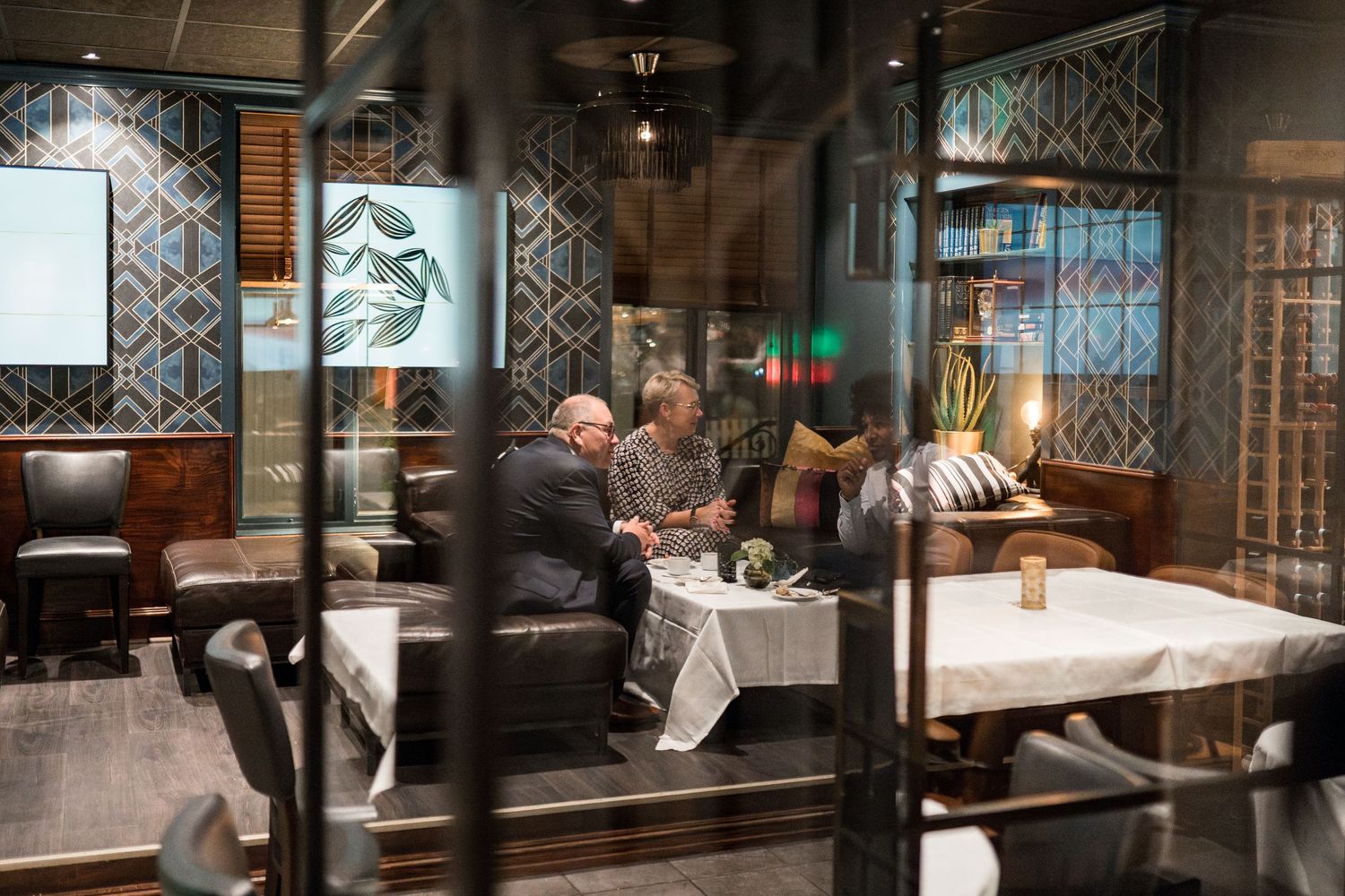 Interior shots of an elegant restaurant with decorative patterns and formal table settings.
