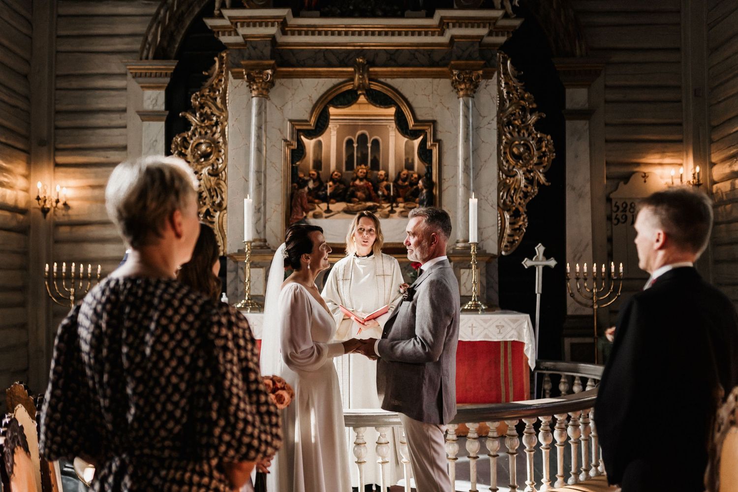 Wedding ceremony taking place in a historic church with decorative architectural elements.