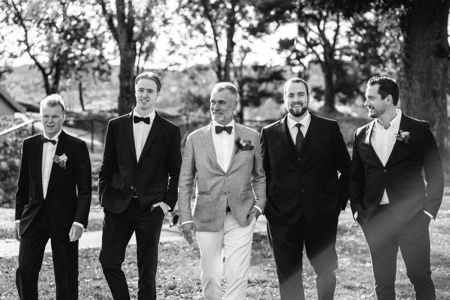 Black and white photo of wedding party standing together outdoors.