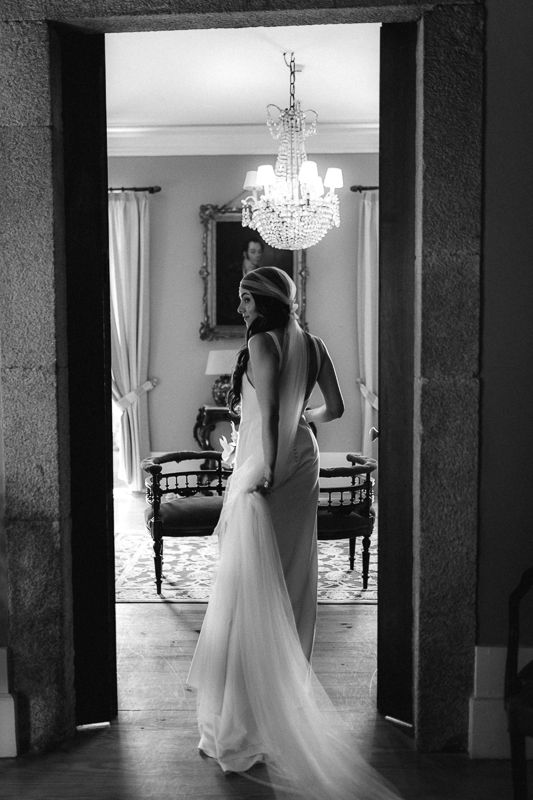 Elegant wedding venue interior with crystal chandeliers and pillars shown in black and white.