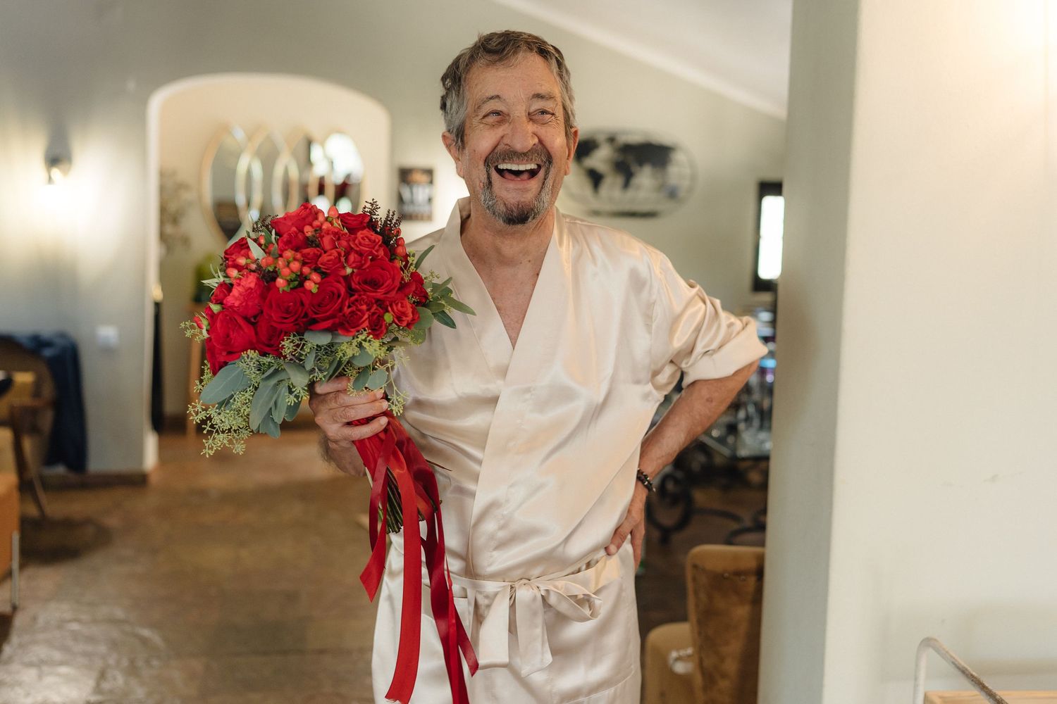 Joyful candid moments captured during wedding preparation in white interior.