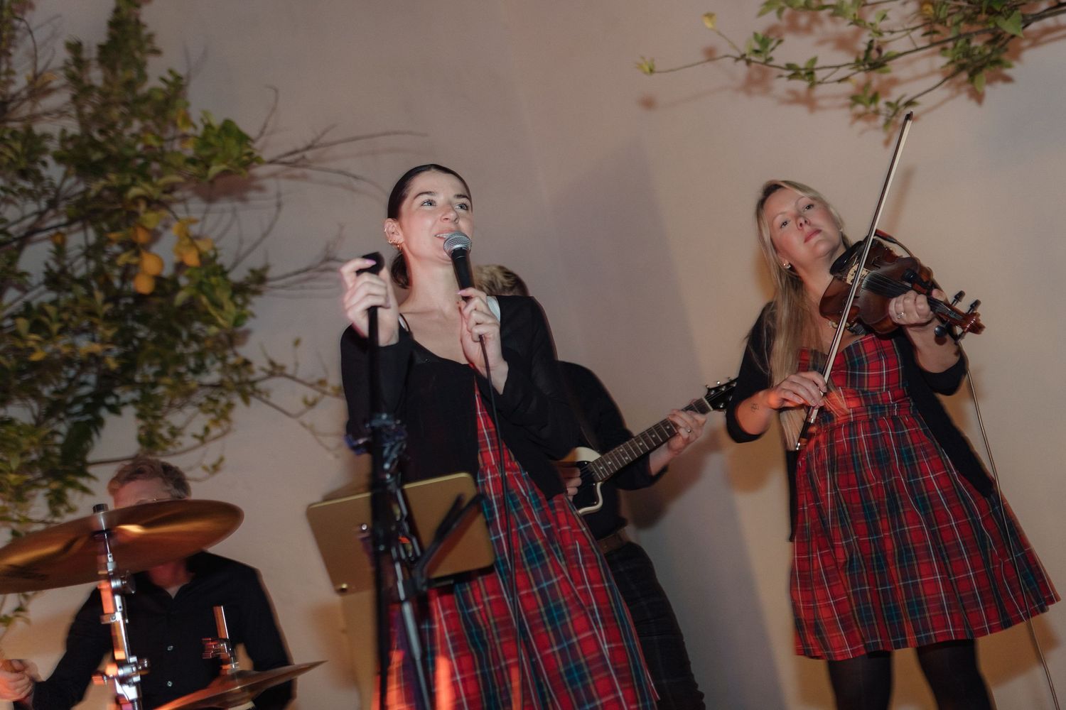 Musicians performing traditional music with instruments at a wedding reception.