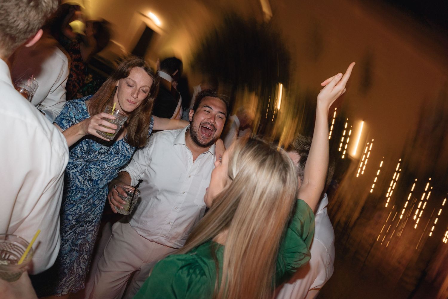 Lively dance floor scene with guests celebrating at an evening wedding party.