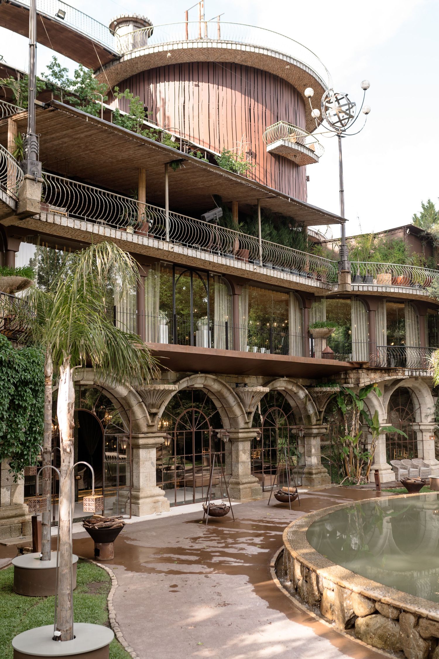 Modern architectural space with curved balconies and reflective pool features.