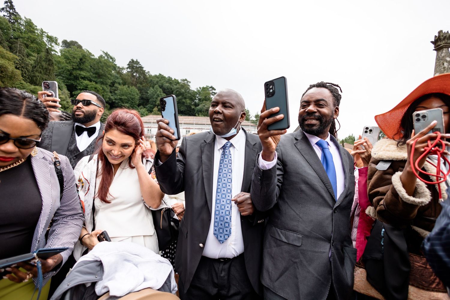 Wedding guests celebrating and taking photos during an outdoor reception.