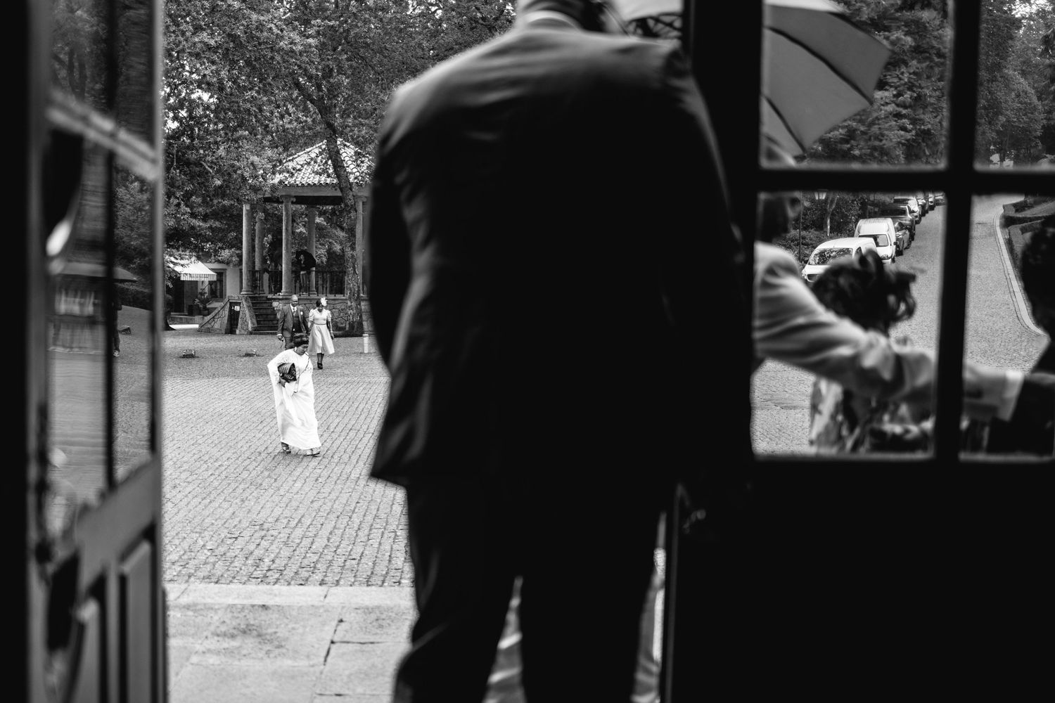 Black and white candid wedding ceremony moments captured through window frames.