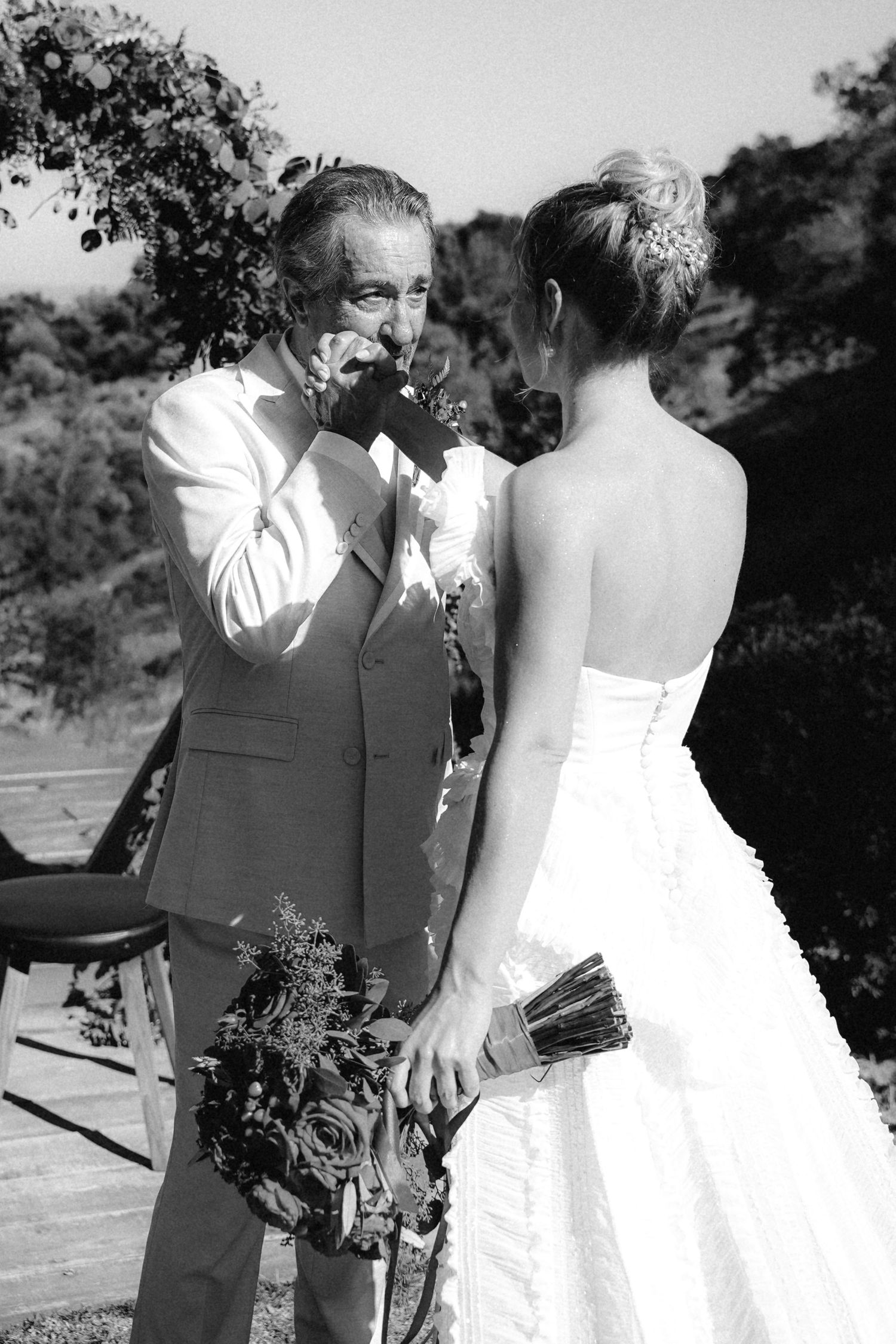 Black and white photos capture intimate moments between bride and guest during outdoor wedding.