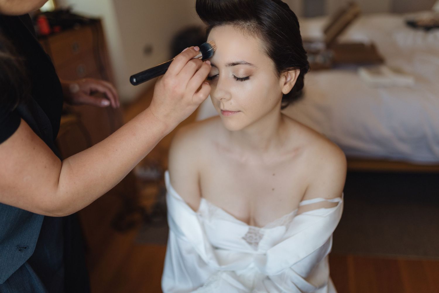 Wedding preparation moment captured in soft natural lighting.