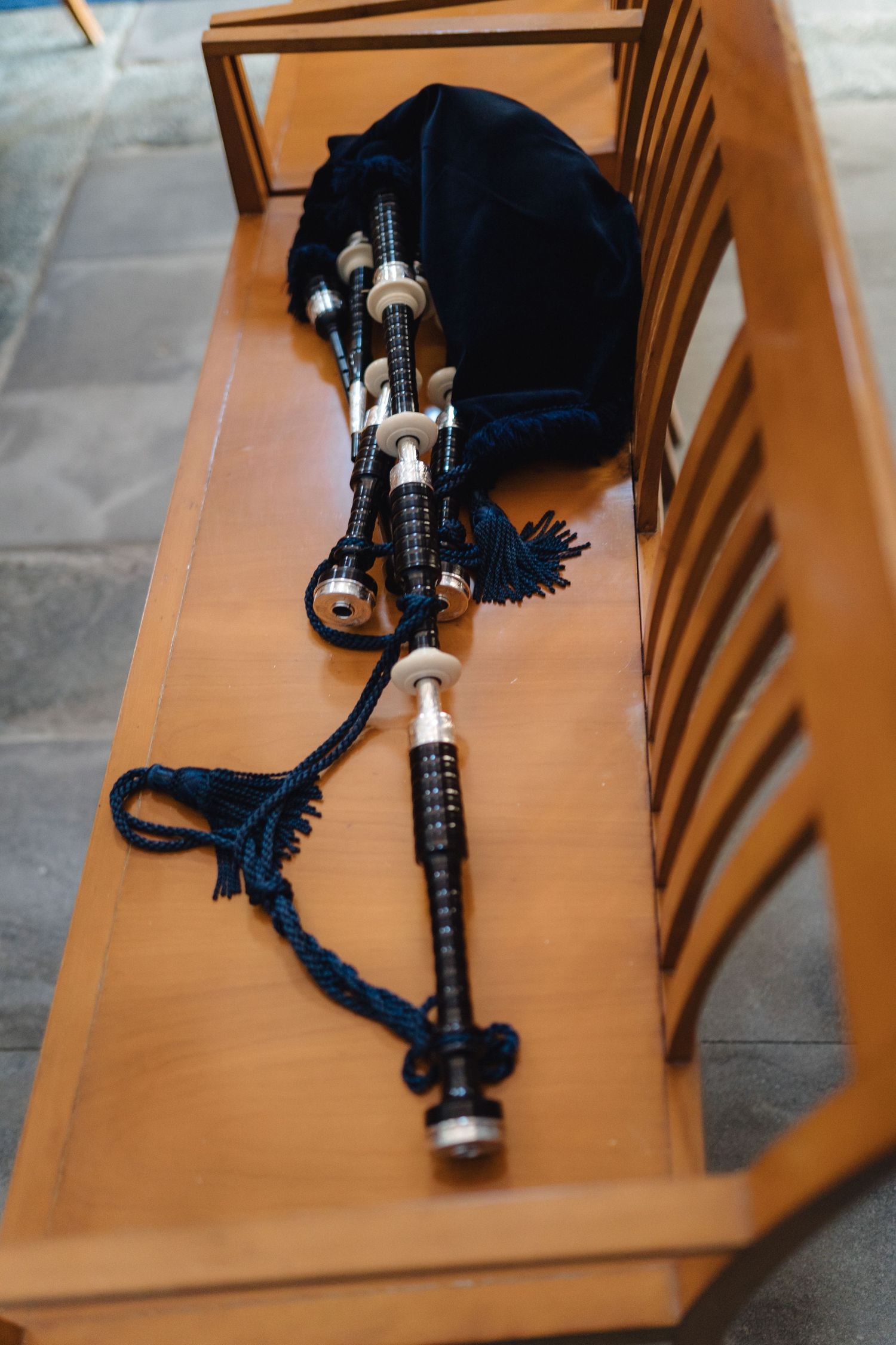 Traditional Scottish bagpipes with black cover lying on wooden surface in multiple detail shots.