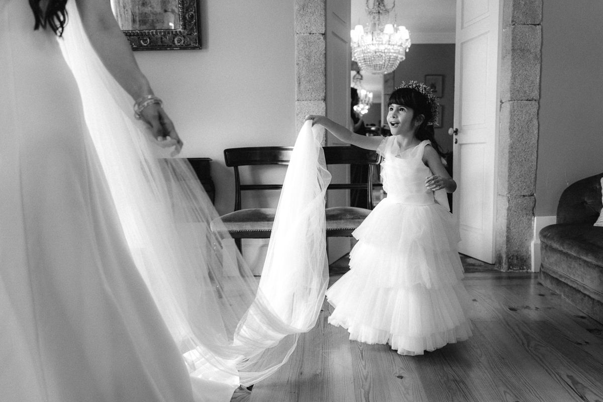 Wedding gowns swishing in motion across an elegant room with chandelier.