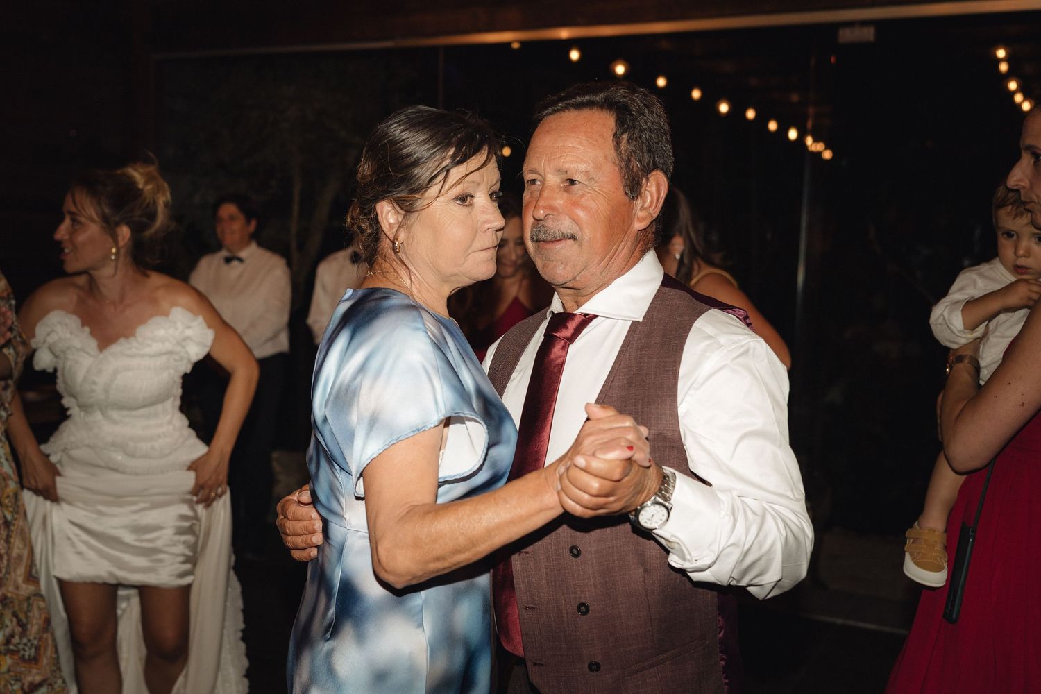Couples dancing together at a dimly lit wedding reception venue.