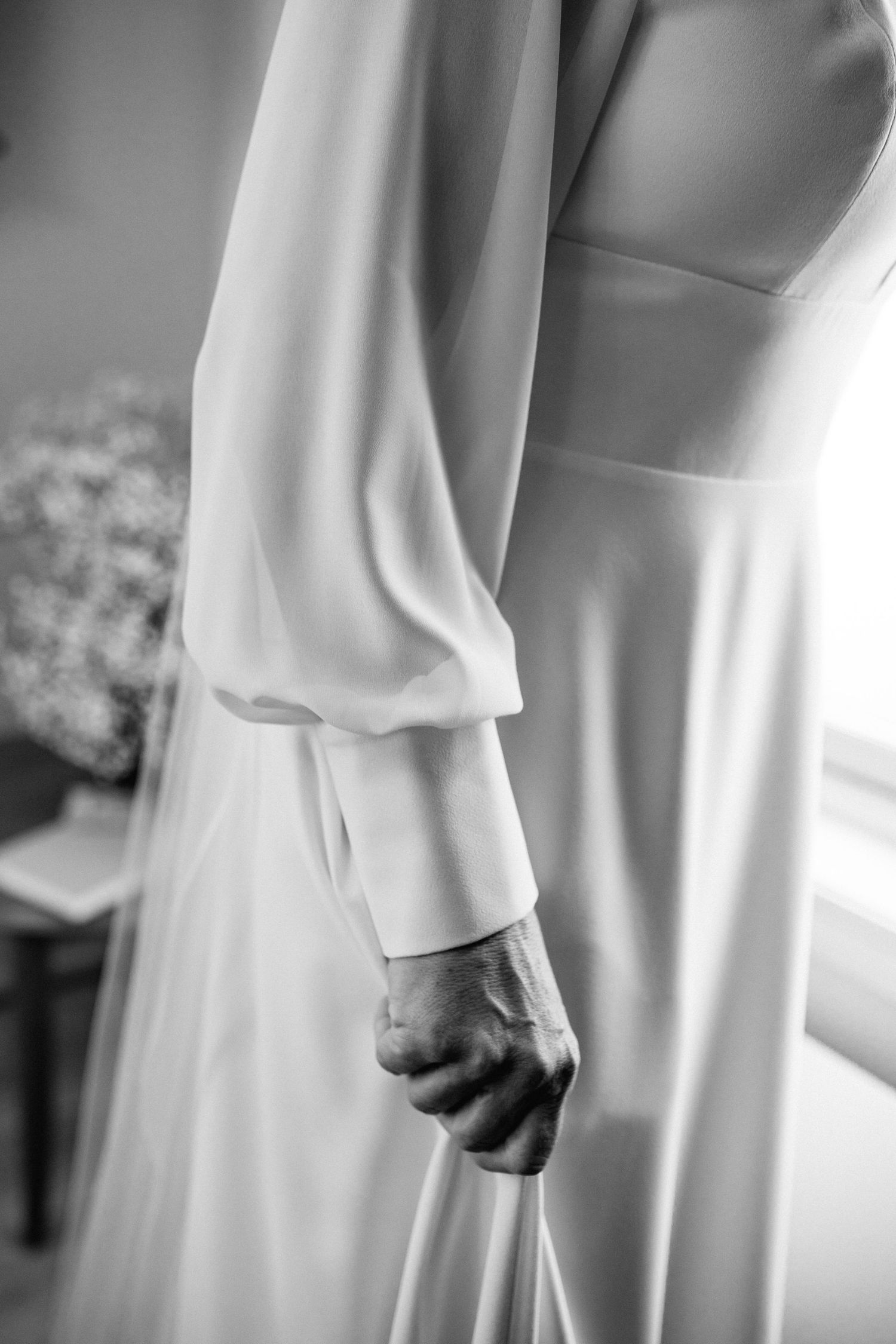 Close-up details of flowing white fabric against a light background.