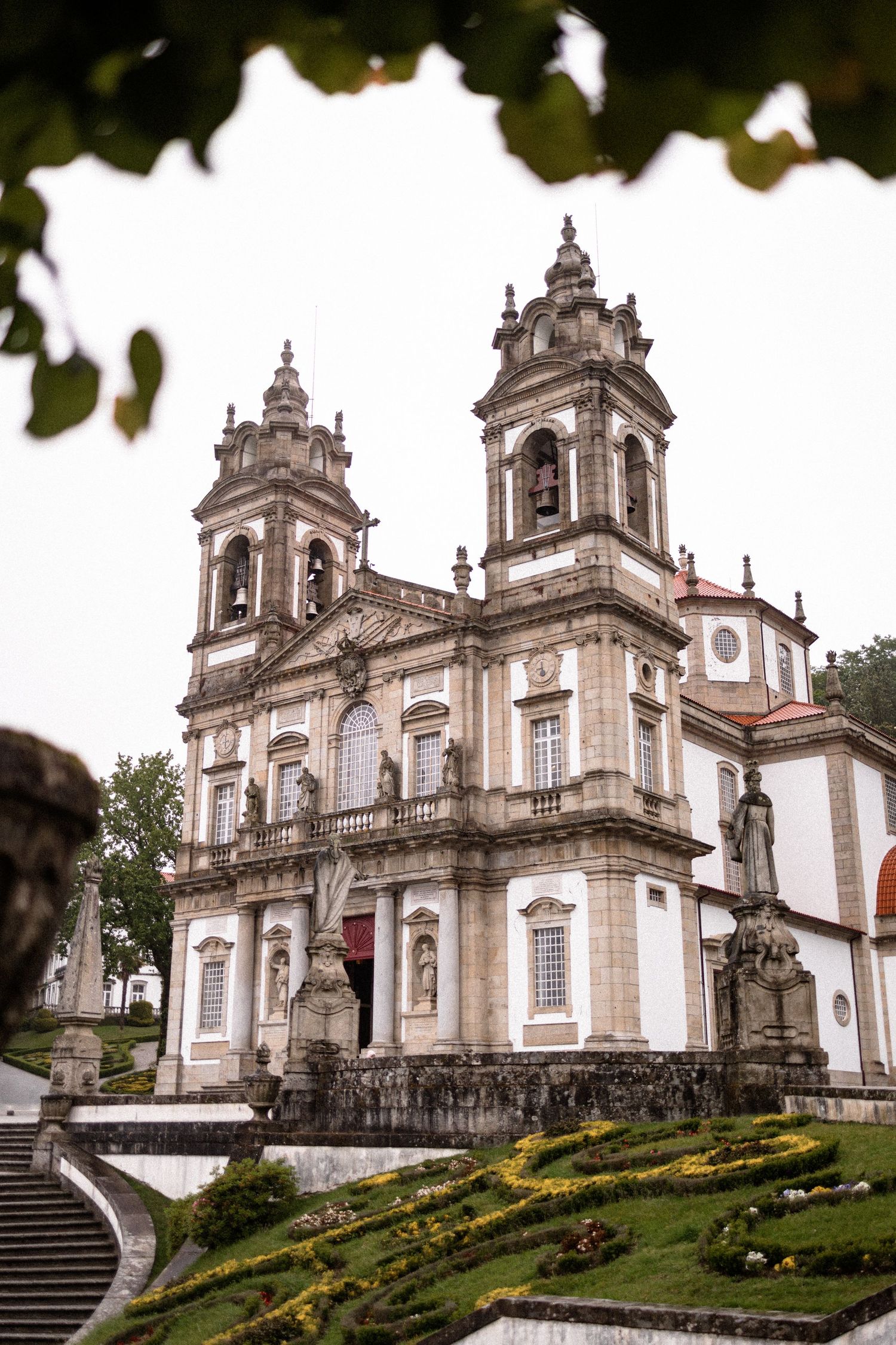 Exterior view of an ornate baroque church with twin towers and stone steps in Portugal.
