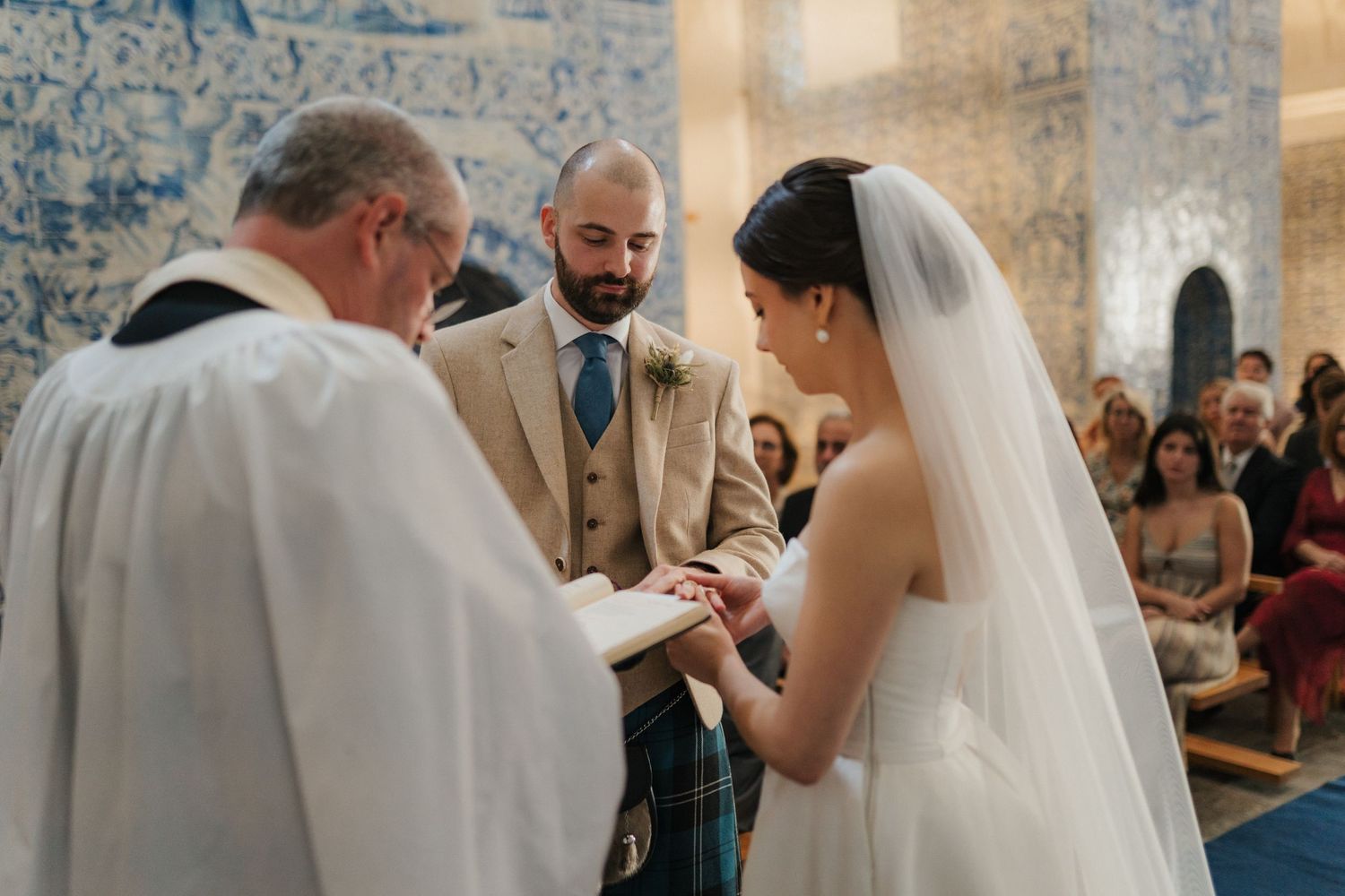 Intimate wedding ceremony moment in front of stunning blue and white Portuguese tile walls.