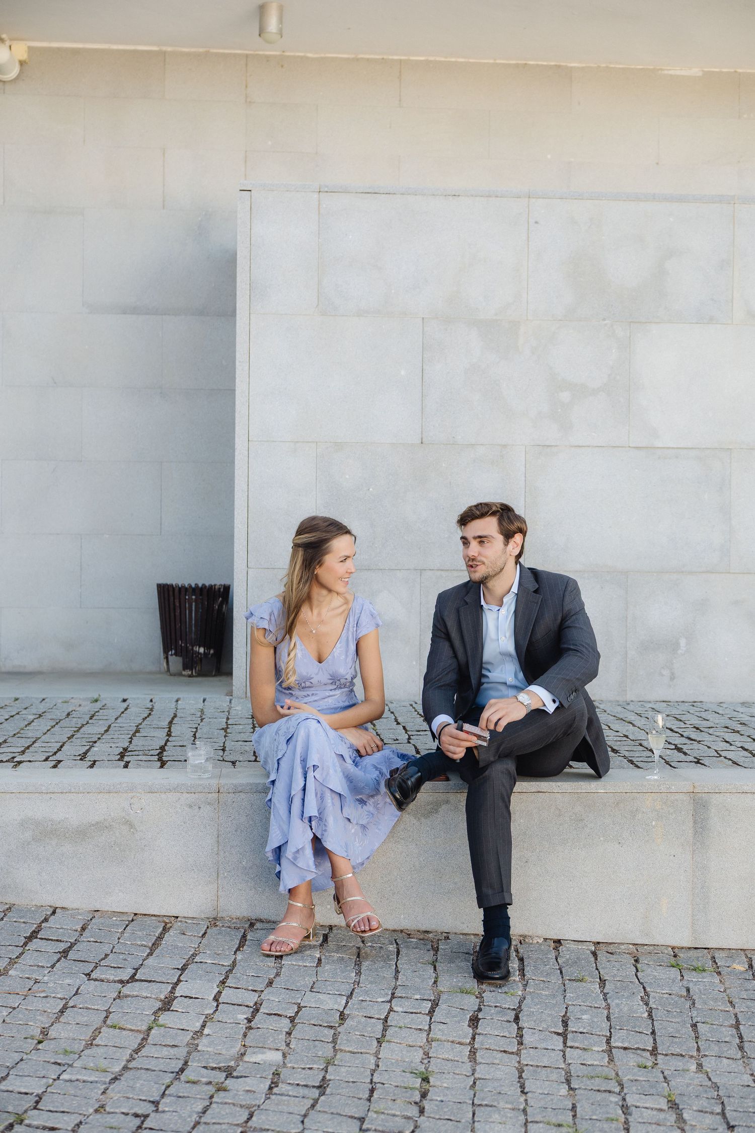 Couple sitting on marble bench having intimate conversation.