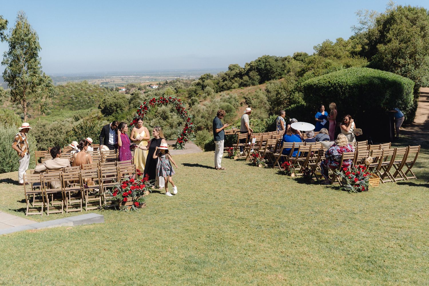 Panoramic view of an outdoor wedding venue with chairs set up on grassy hillside.
