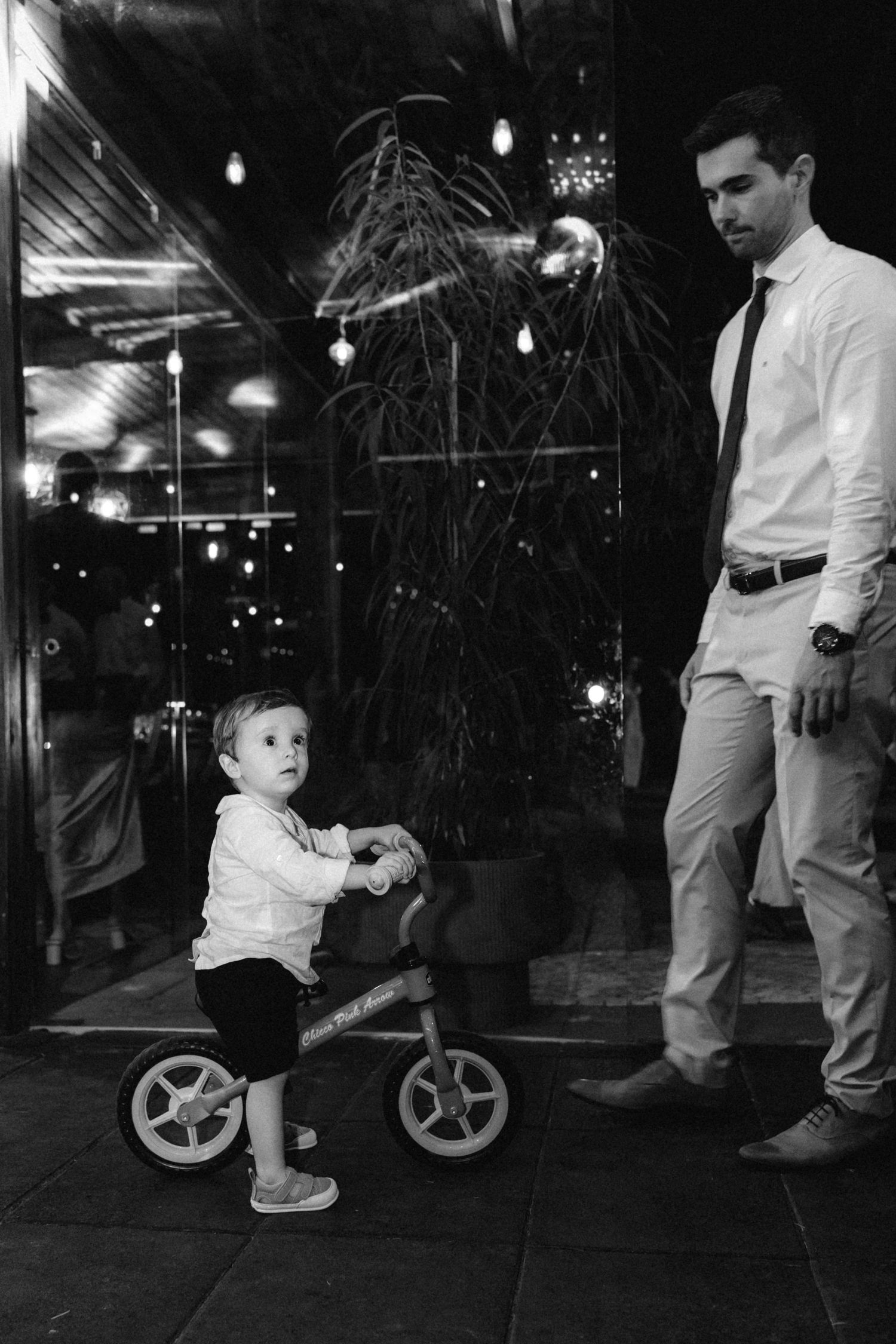 Child playing with a wheeled toy at a nighttime gathering.