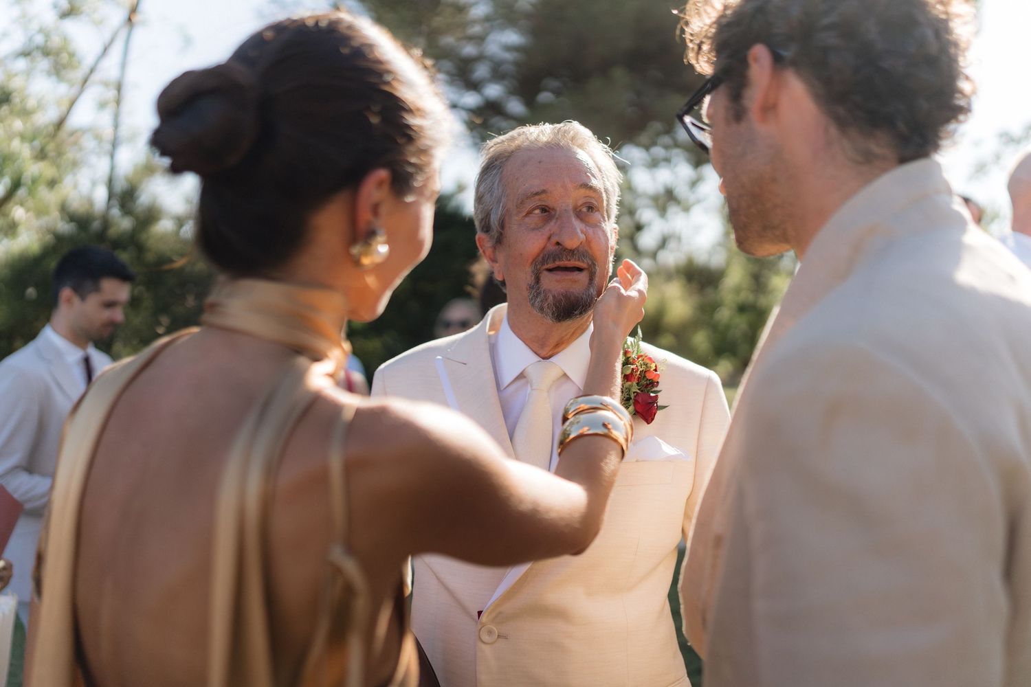 Wedding attendees gathered in casual conversation during an outdoor afternoon reception.