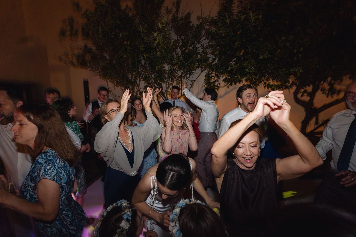 Silhouettes of people dancing in a dark room with atmospheric lighting.