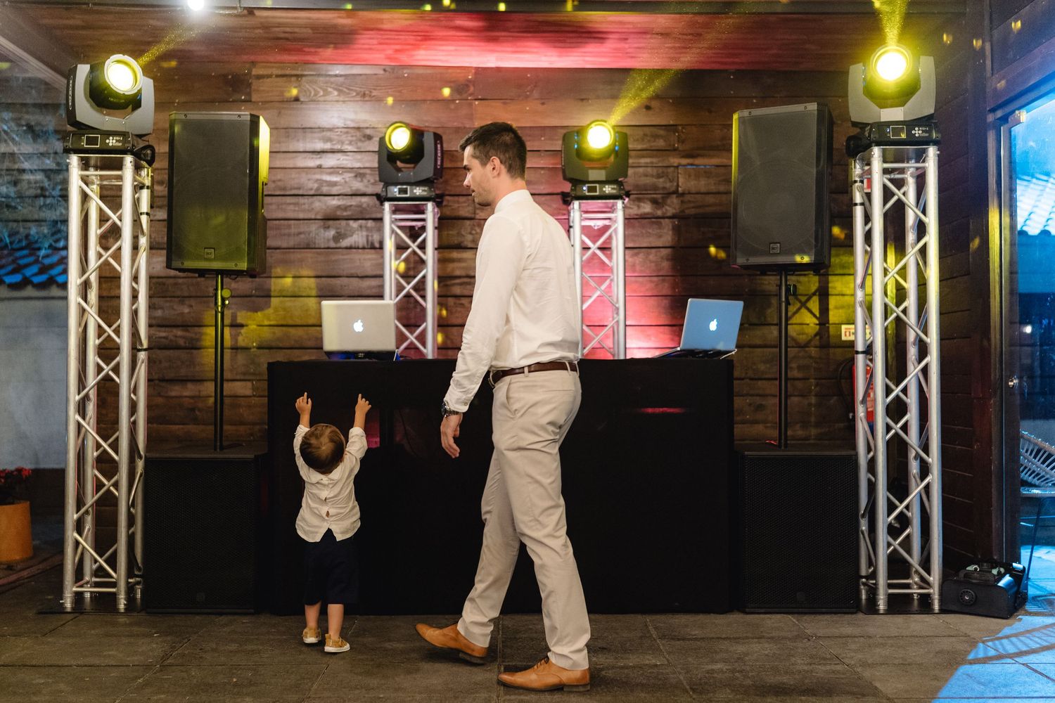 Dance floor setup with professional lighting and wooden wall decor at an event venue.