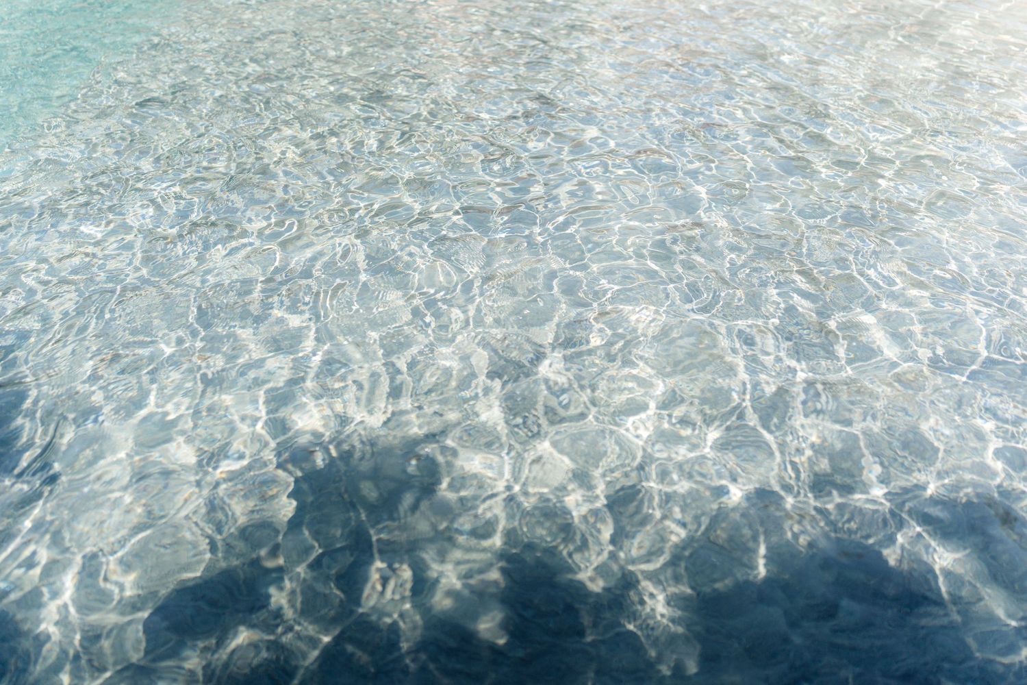 Sparkling pool water surface creating abstract reflective patterns.