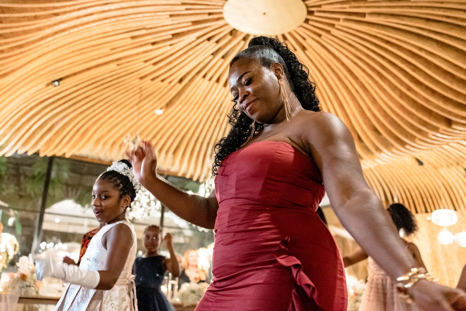 Wedding guests dancing under a unique sunburst-patterned ceiling.