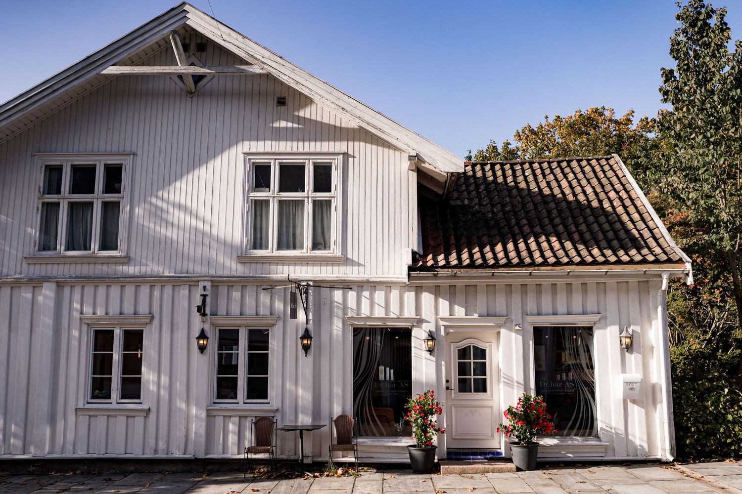 White wooden house exterior with multiple windows and a classic Scandinavian design.