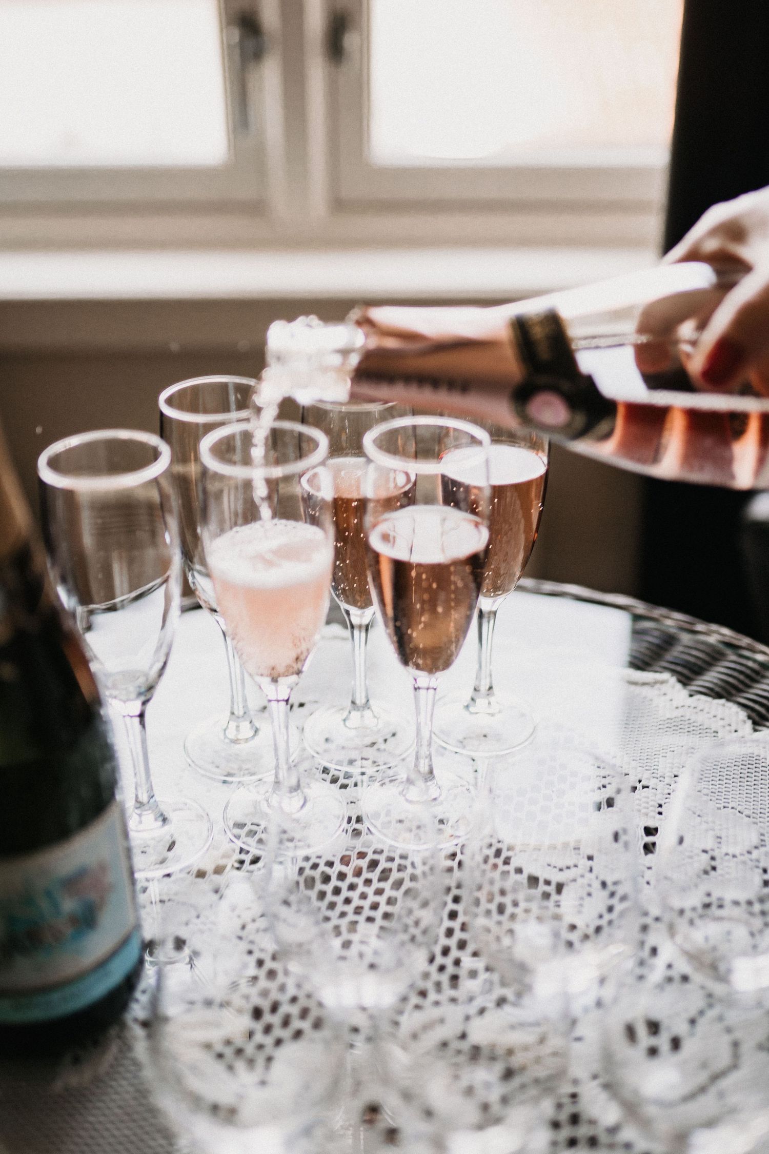 Crystal champagne glasses arranged on a decorative mirrored tray.