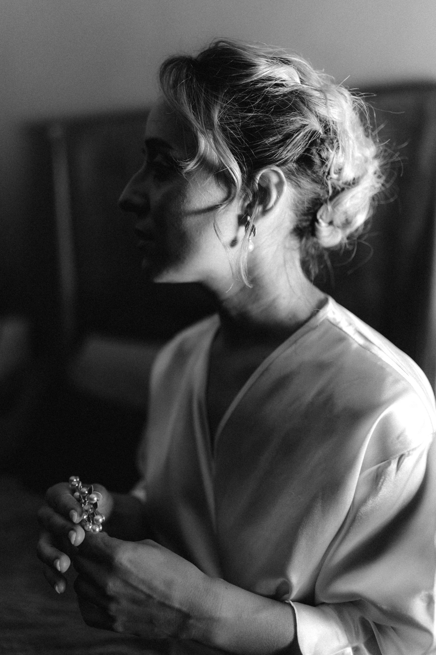 Artistic black and white profile shot of person in white silk wrap dress.