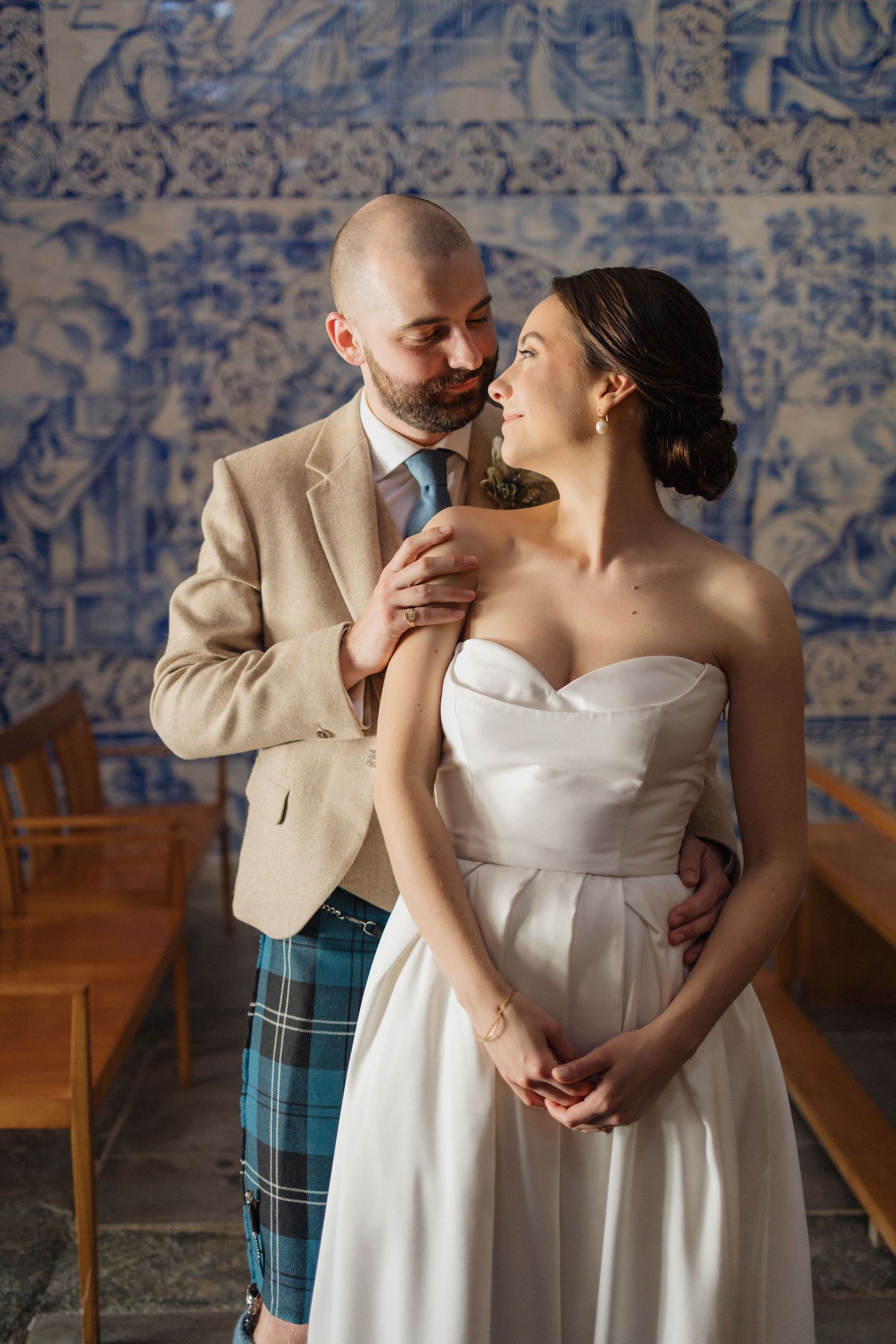 Wedding portraits against a backdrop of traditional blue and white Portuguese azulejo tiles.