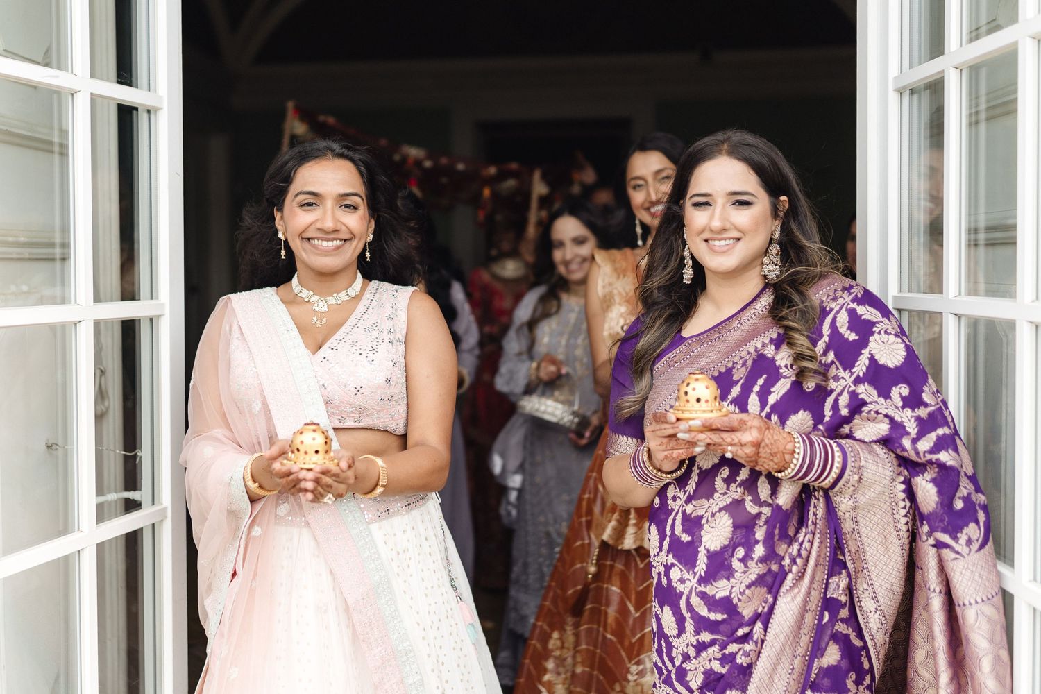 Wedding guests in colorful traditional Indian attire gathered at an outdoor venue.