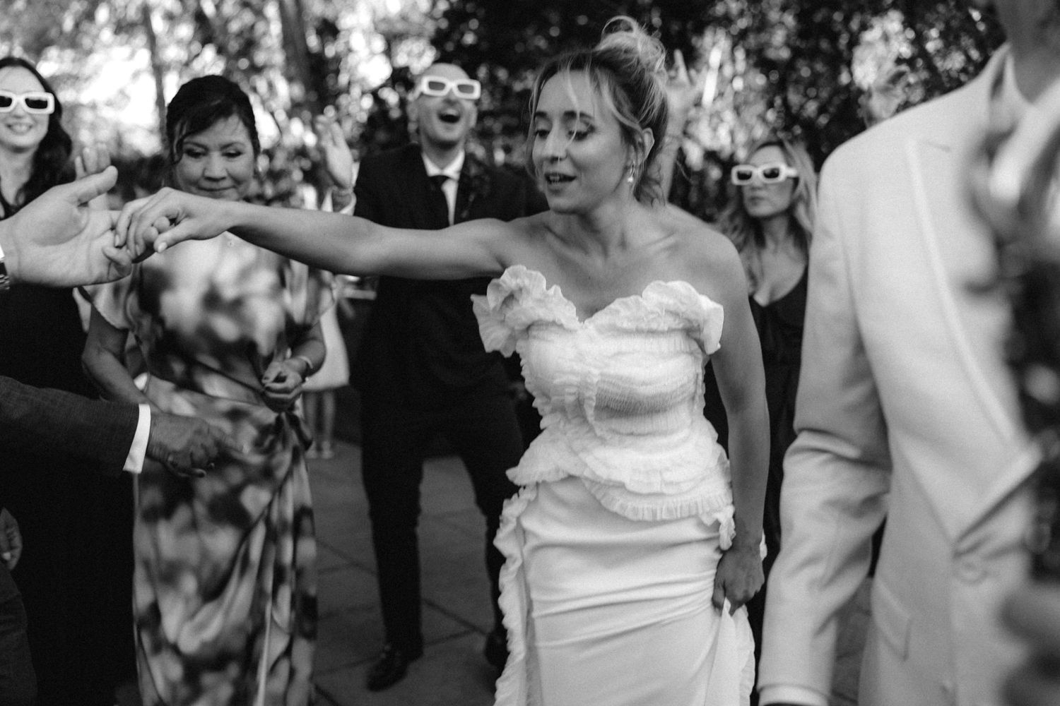 Black and white candid shots of wedding guests enjoying a dance party.