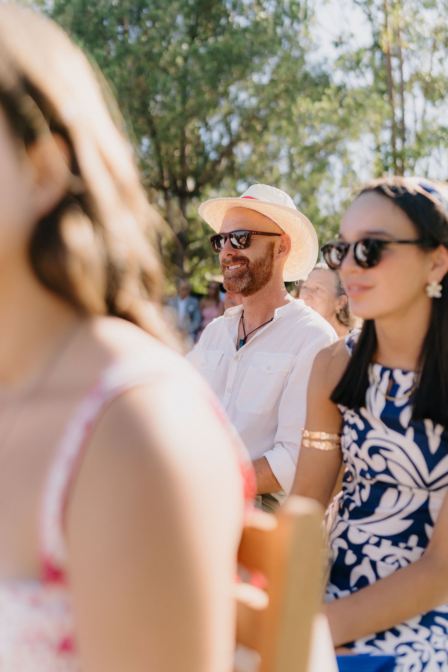 Wedding guests in casual summer attire enjoy the outdoor celebration.