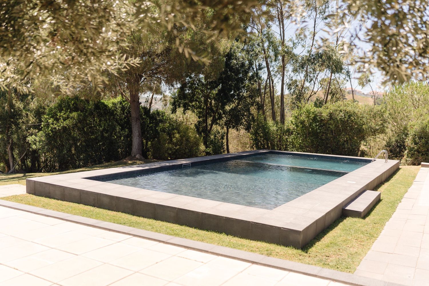 Modern infinity pool with clean lines overlooking a scenic landscape.