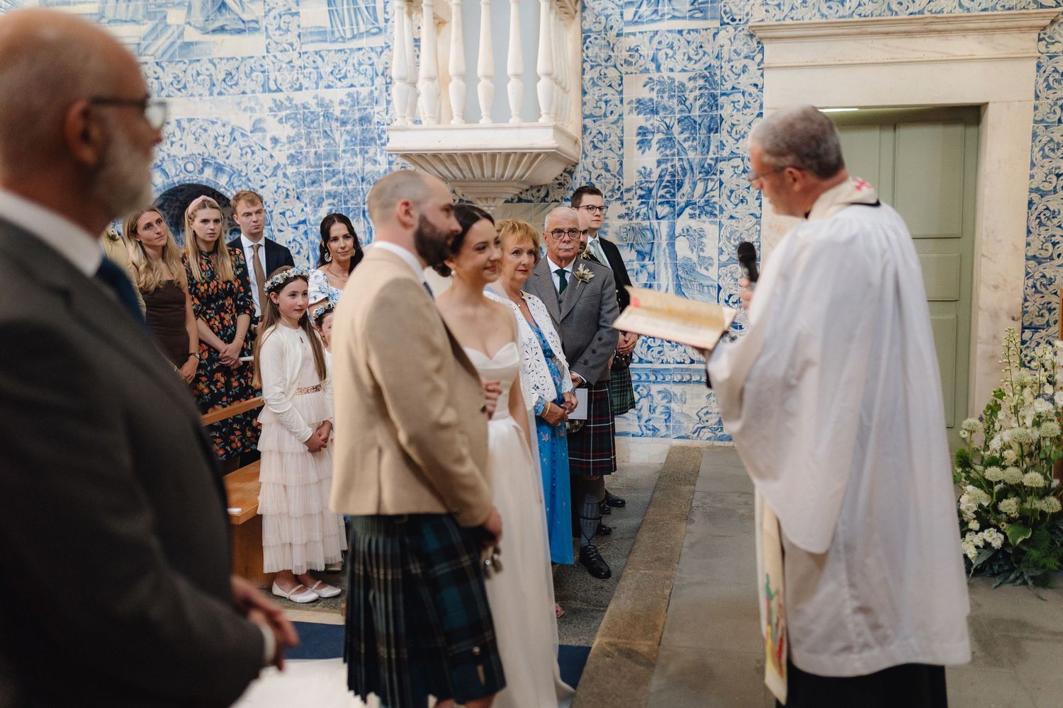 Wedding celebration in a historic chapel adorned with blue Portuguese tiles.