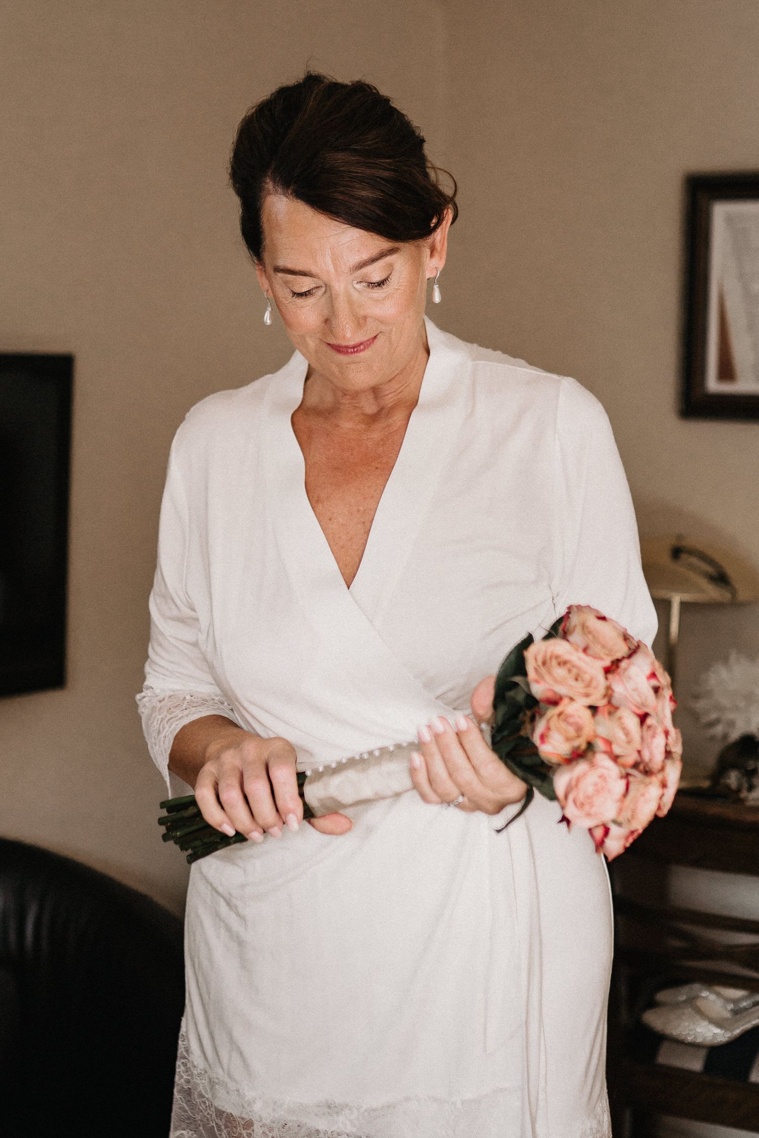A sequence of photos showing someone in a white robe holding and arranging pink roses.