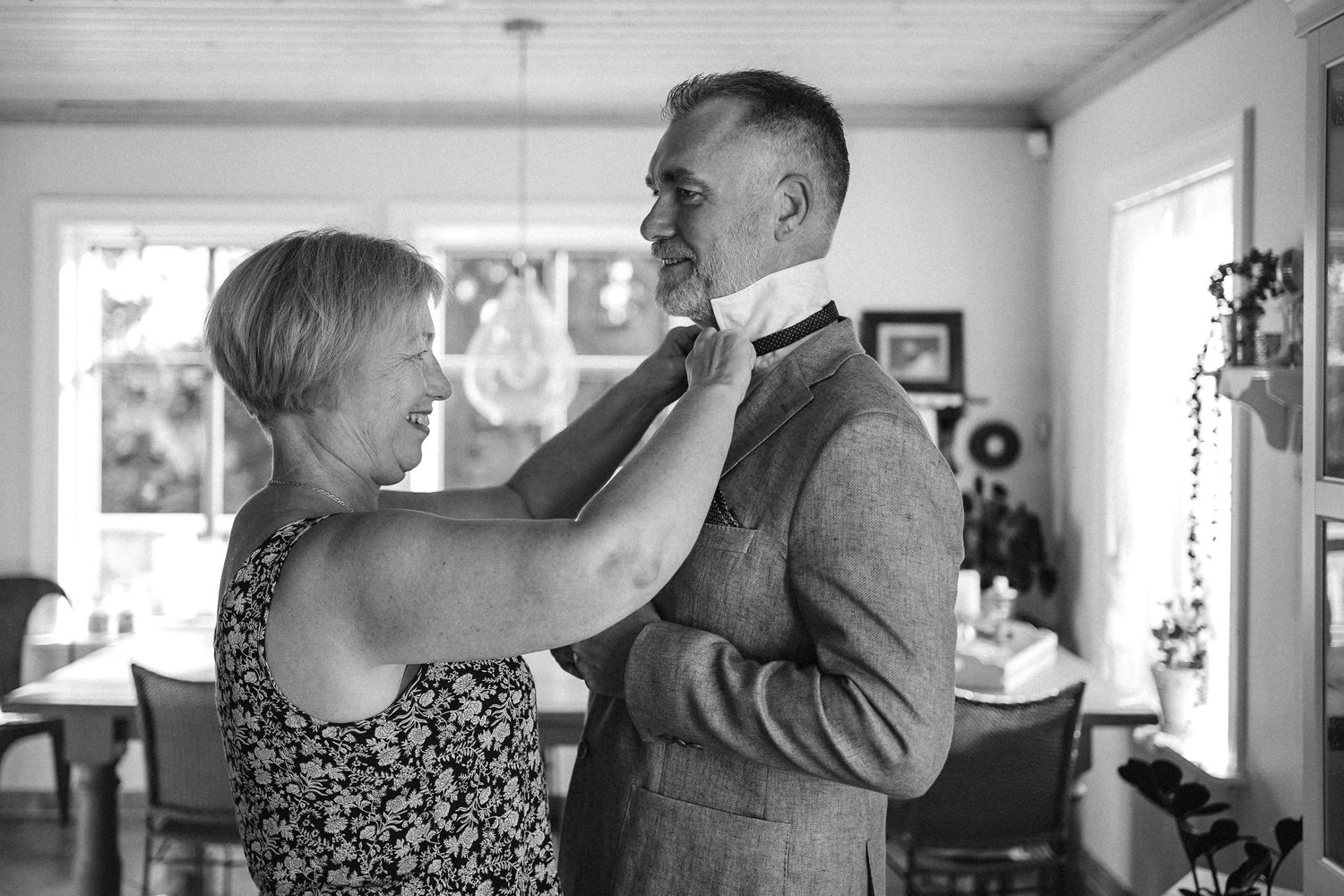 A series of black and white photos showing people dancing and embracing in an intimate indoor setting.