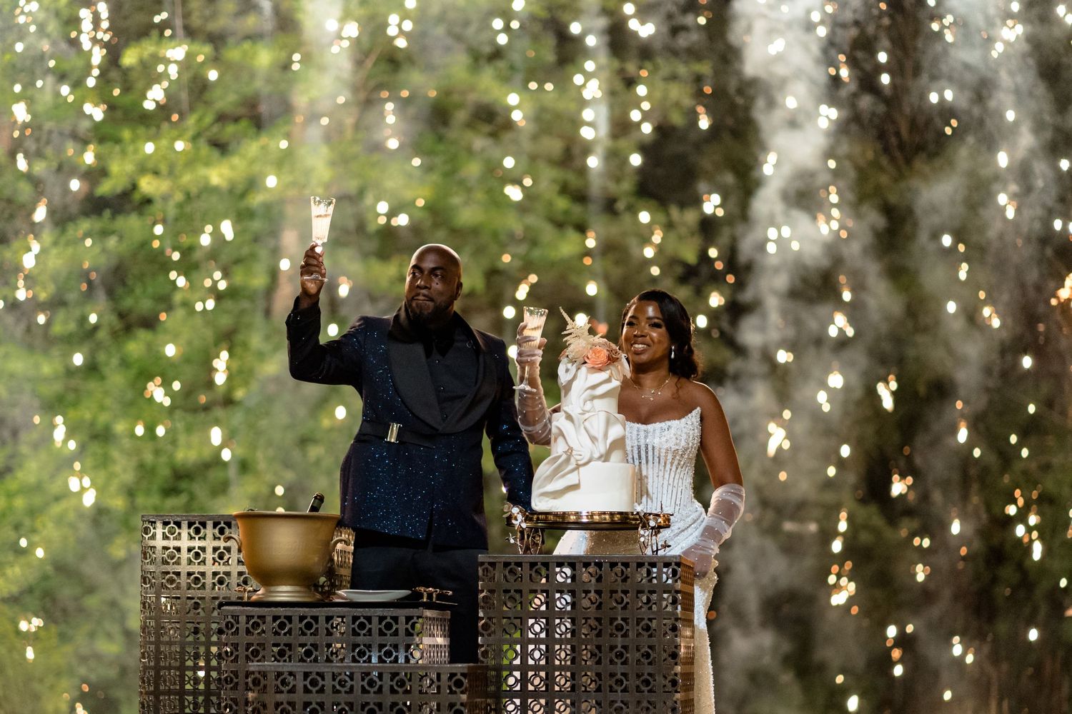 Fairy lights create a magical backdrop for an outdoor wedding celebration.