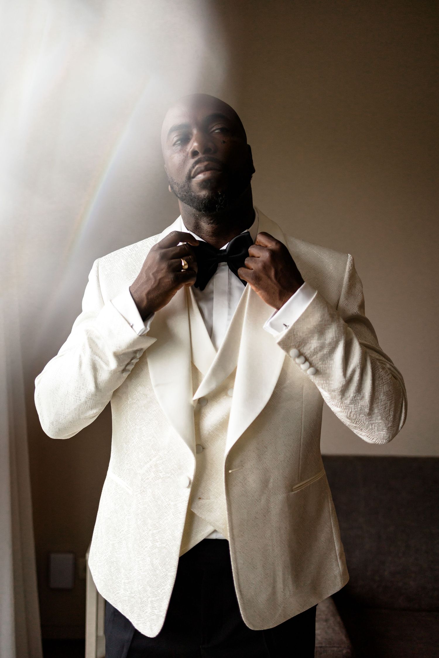 Close-up shots of groom preparing his formal white attire before the ceremony.