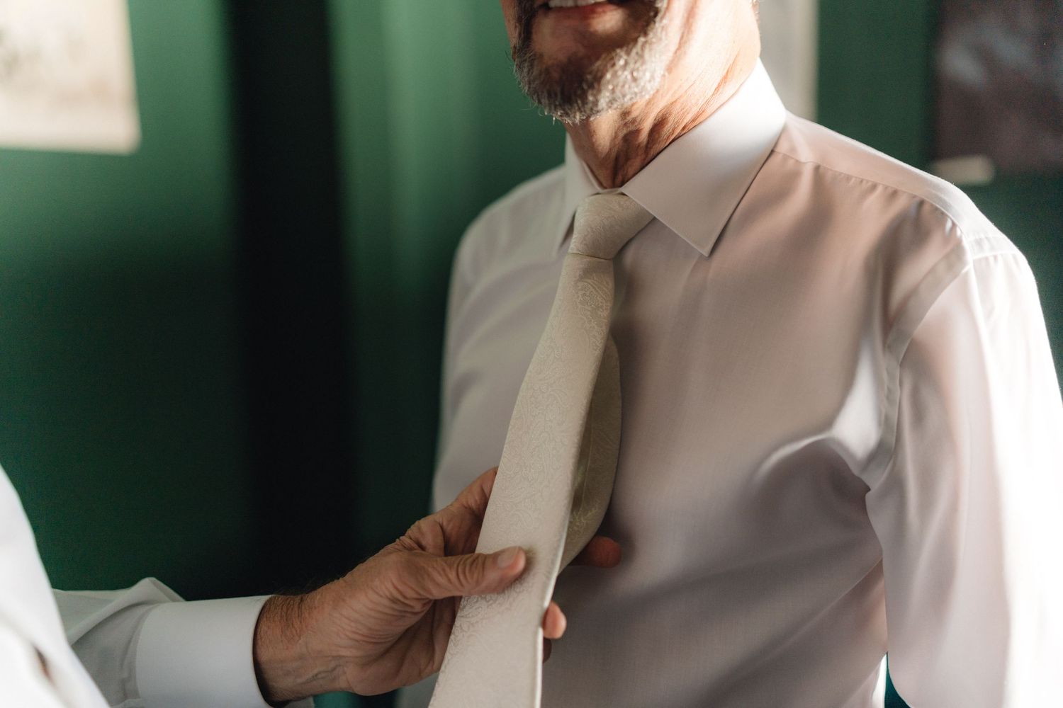Candid moments captured in natural light against green walls and white attire.