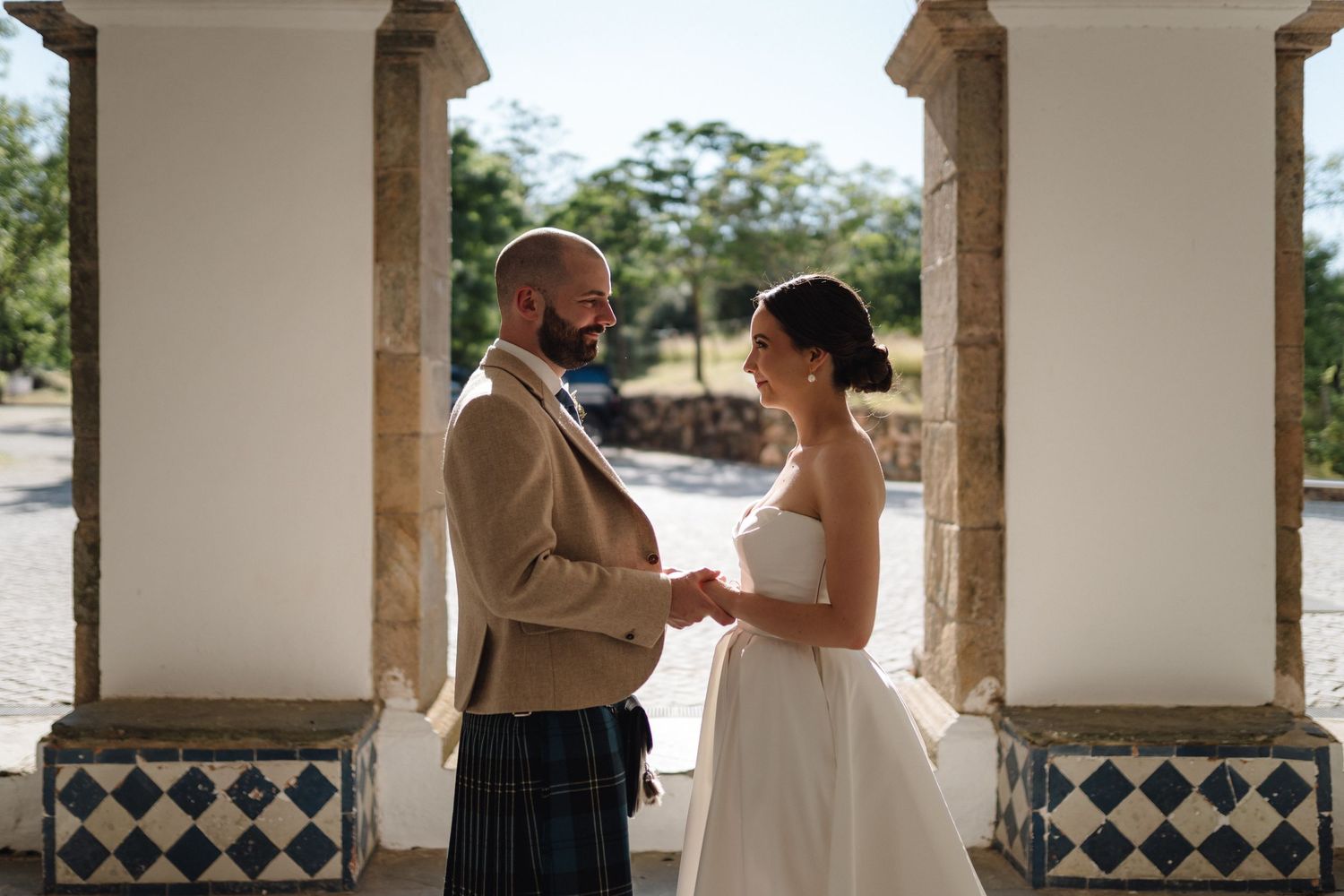 Stone colonnade with blue and white tile details at wedding venue.