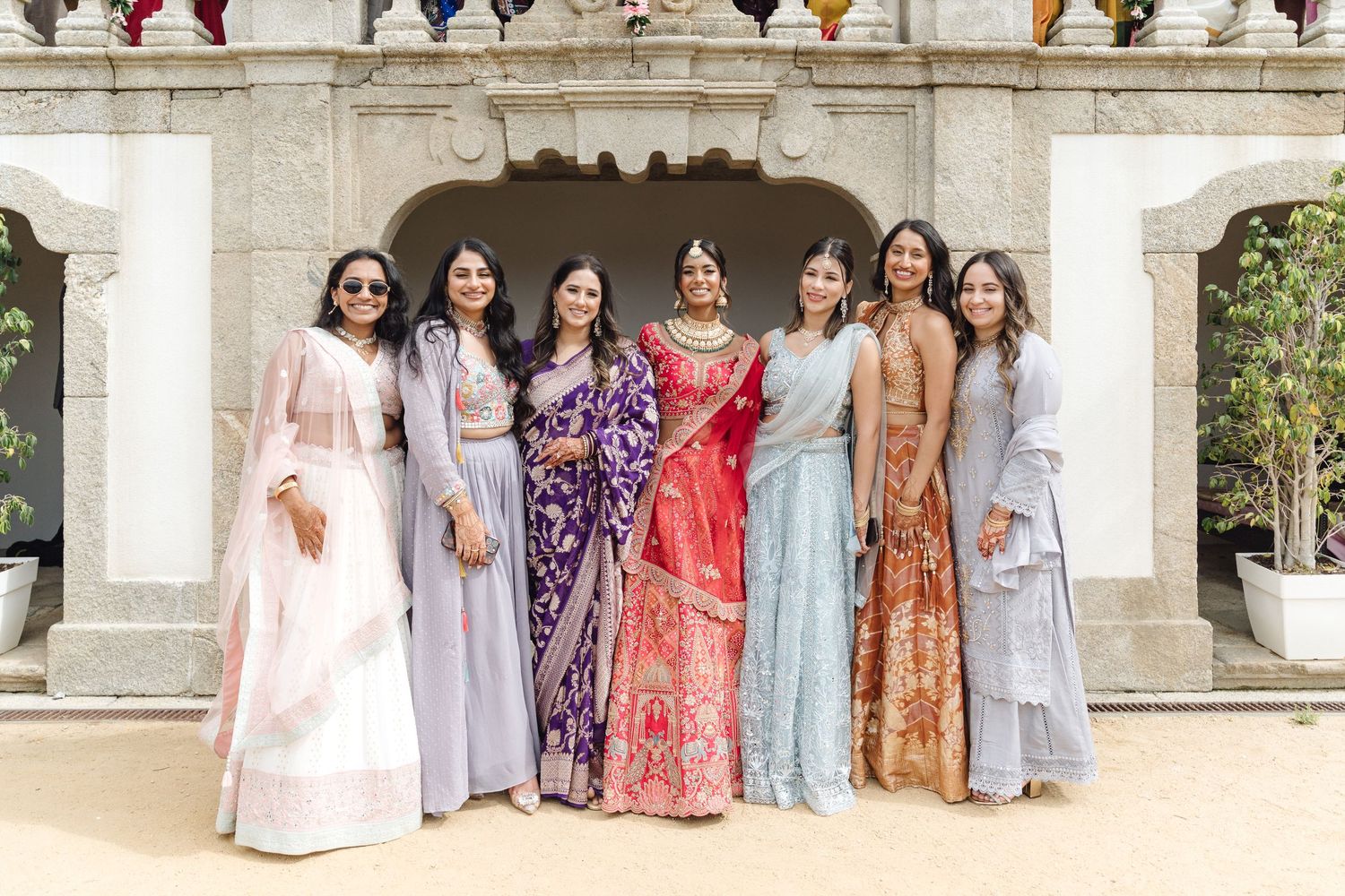 A row of colorful traditional Indian saris and dresses displayed at a wedding celebration.
