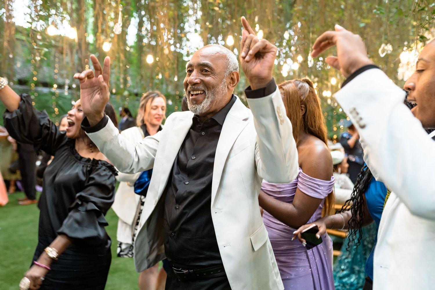 Wedding guests dancing and celebrating at an outdoor reception.