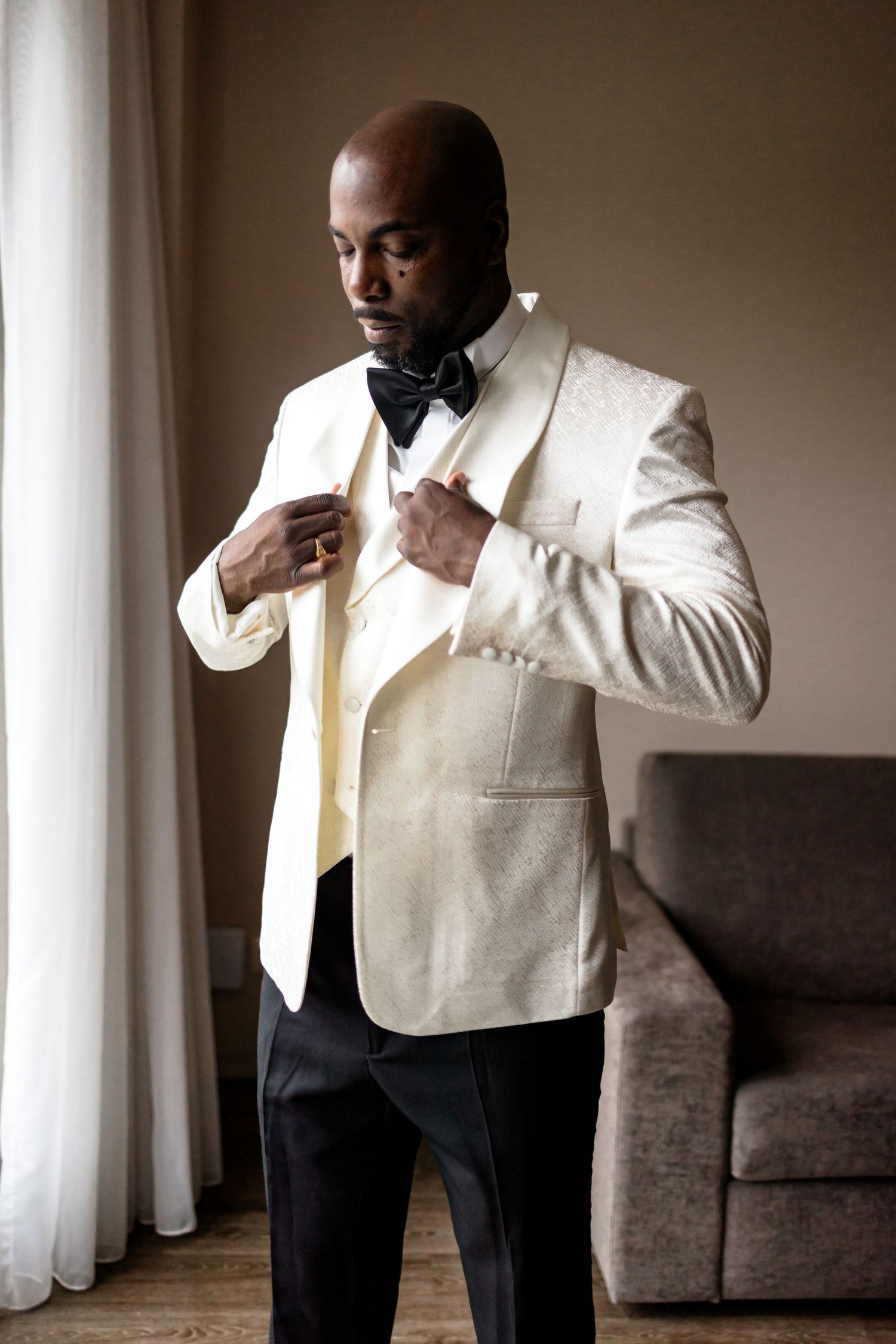 A sequence of photos showing a groom adjusting his white formal vest and tie.