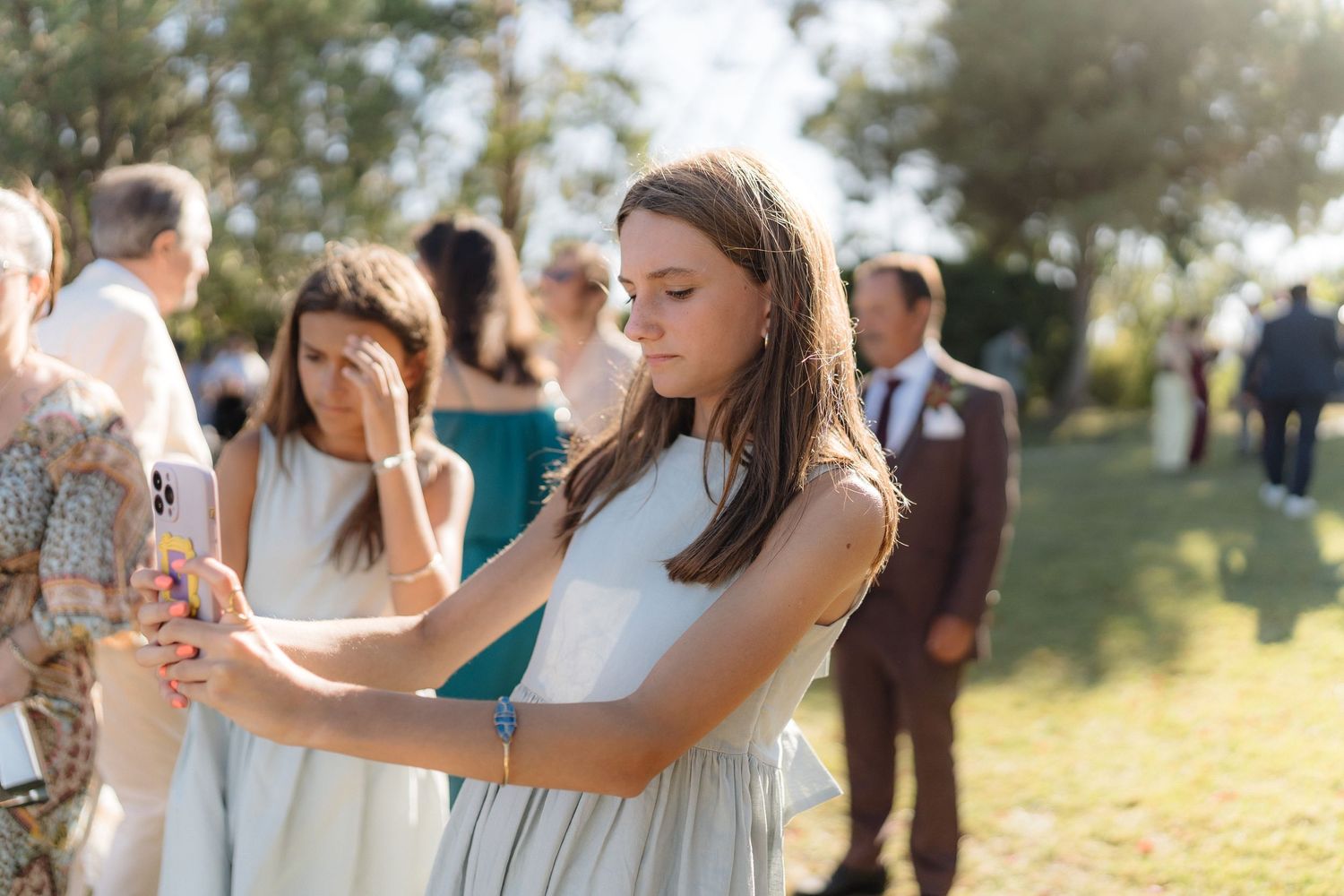Wedding party members share candid moments of celebration in an outdoor garden setting.